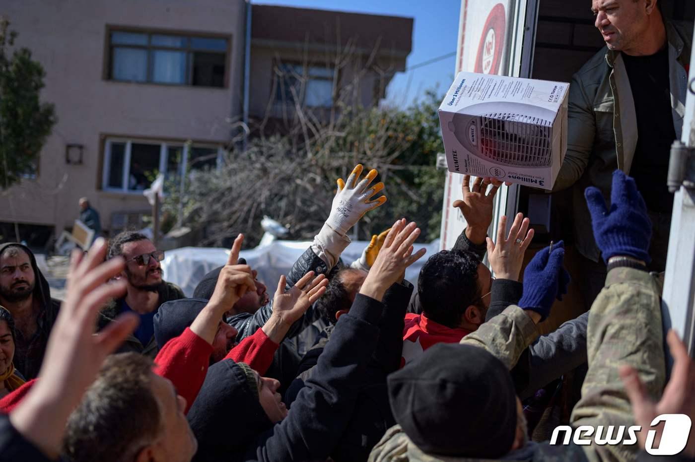 16일 &#40;현지시간&#41; 규모 7.8의 지진이 강타한 튀르키예 하타이에서 주민들이 음식과 옷가지를 배급 받기 위해 손을 내밀고 있다. ⓒ AFP=뉴스1 ⓒ News1 우동명 기자