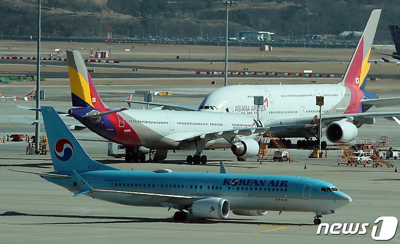 19일 오후 인천국제공항 전망대에서 바라본 계류장에서 대한항공 항공기가 아시아나항공 항공기 앞을 지나고 있다. 유럽연합&#40;EU&#41; 반독점 규제당국은 대한항공의 아시아나항공 기업결합 관련해 2단계 심사에 착수했으며, 2단계 심사 결과는 오는 7월5일 발표될 예정이다. 2023.2.19/뉴스1 ⓒ News1 박정호 기자