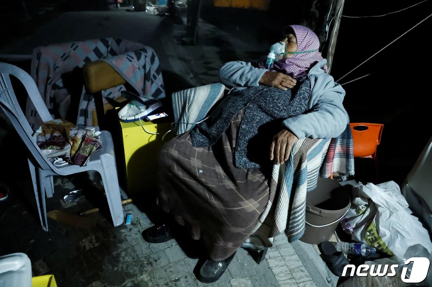 20&#40;현지시간&#41; 오후 8시4분께 튀르키예 남부 국경지역인 하타이주 안타키아 데프네에서 규모 6.4 지진이 발생한 가운데 한 여성이 인공호흡기를 달고 거리에서 휴식을 취하고 있다. ⓒ 로이터=뉴스1 ⓒ News1 정윤영 기자