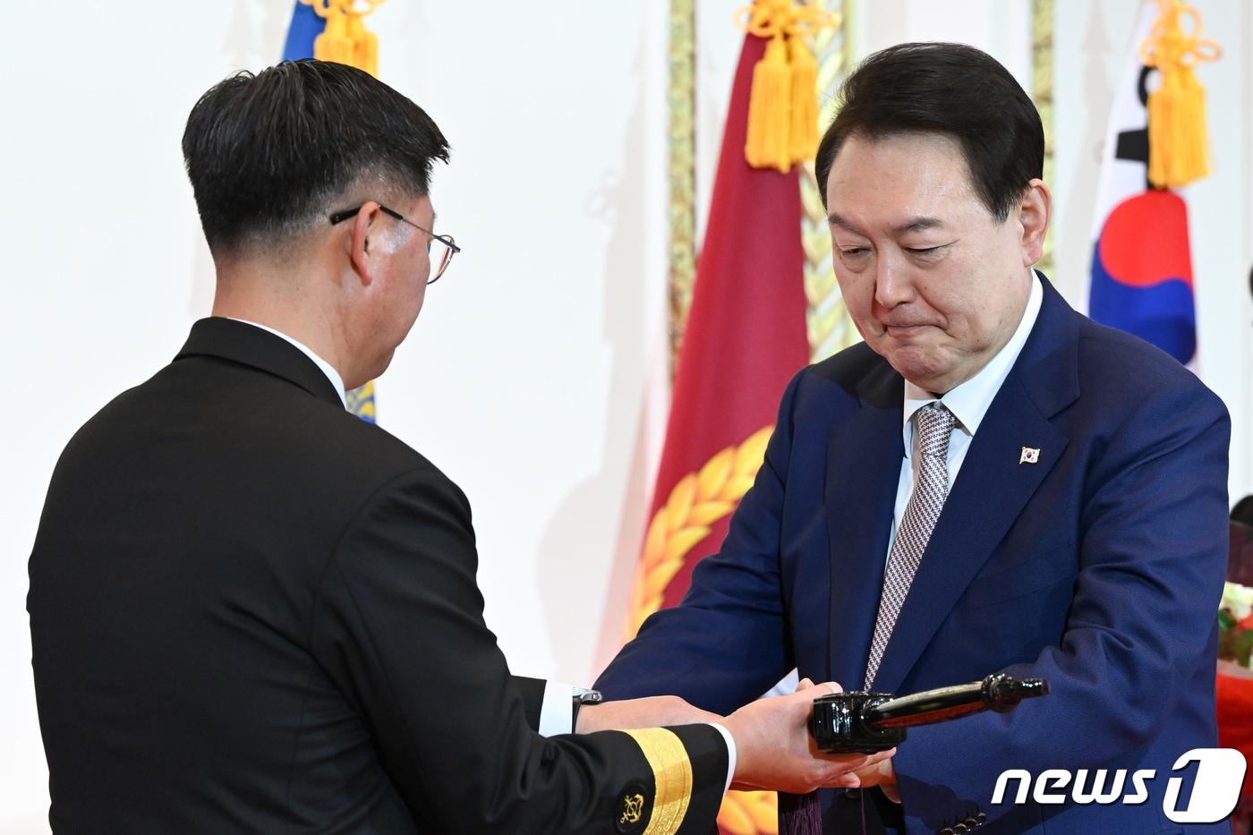 윤석열 대통령이 3일 오후 청와대 영빈관에서 열린 준장&#40;准將&#41; 진급 장성 삼정검 수여식에서 진급 장성에게 삼정검을 수여하고 있다. 삼정검의 ‘삼정’은 육·해·공군이 일치해 호국·통일·번영의 3가지 정신을 달성한다는 의미다. &#40;대통령실 제공&#41;/뉴스1 ⓒ News1 오대일 기자