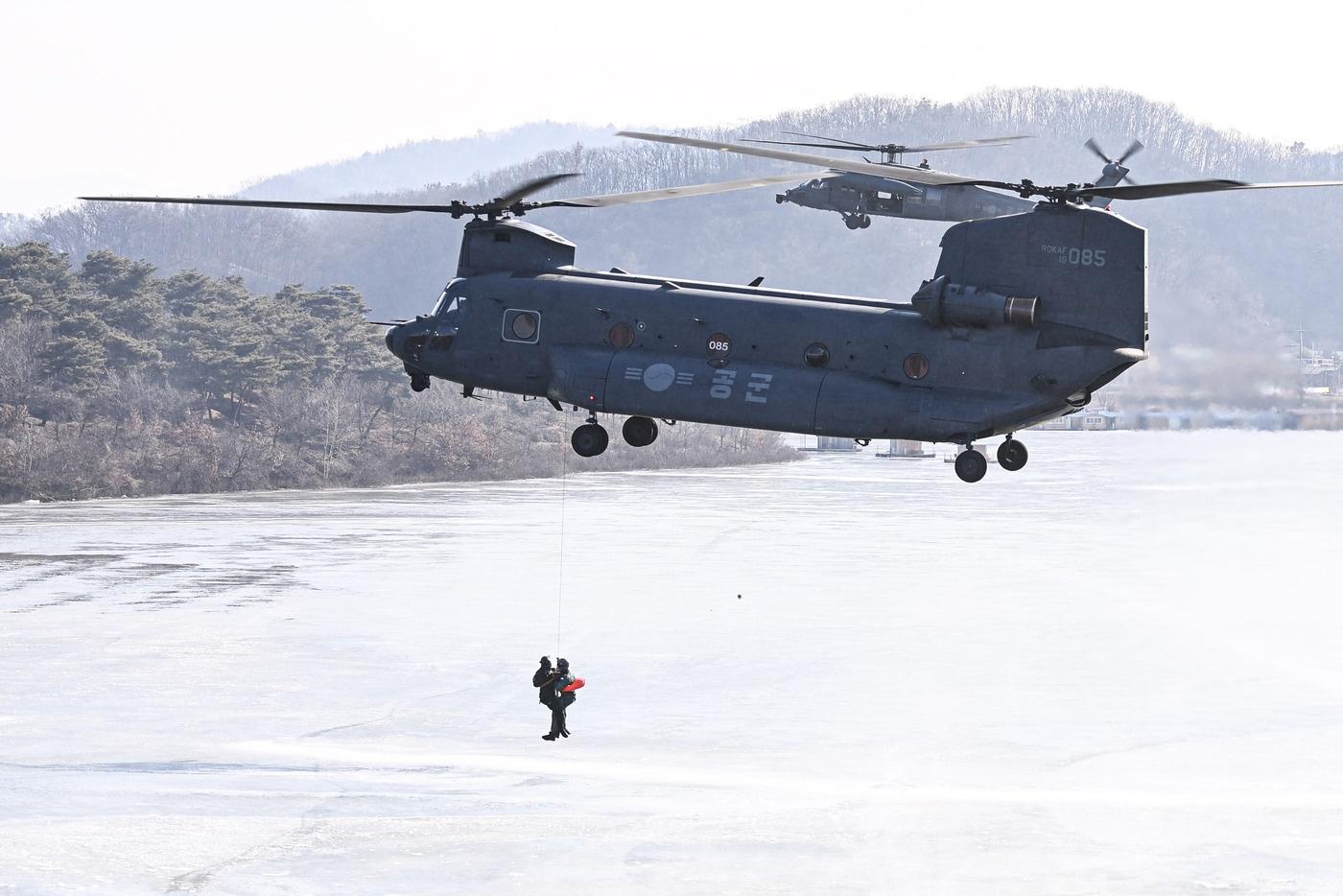 HH-32 탐색구조헬기&#40;오른쪽&#41;가 구조용 인양기&#40;HOIST&#41;로 조난자를 구조하고 있다.&#40;공군 제공&#41;