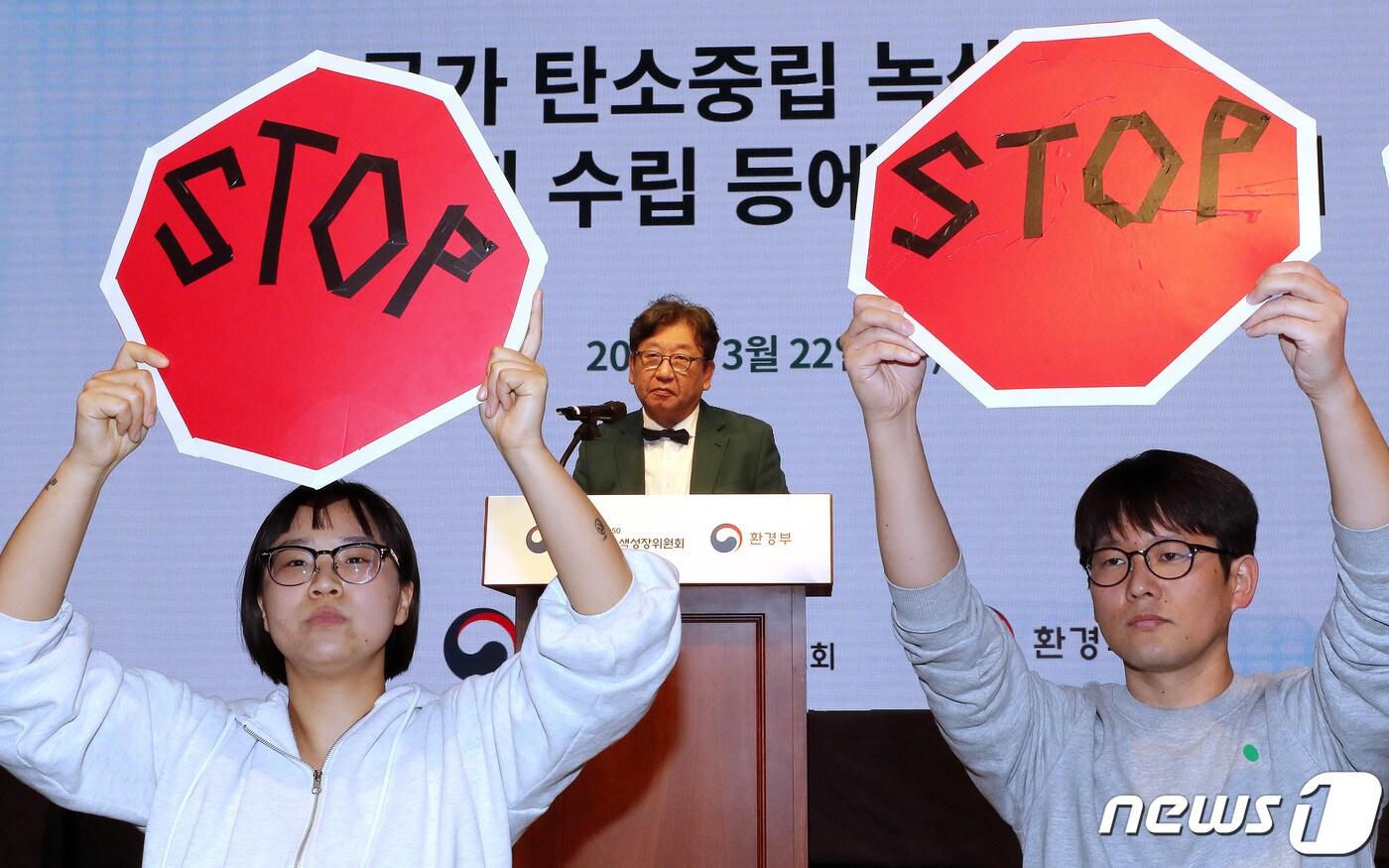 김상협 탄소중립녹색성장위원장이 지난 22일 서울 강남구 한국과학기술회관에서 열린 국가탄소중립 녹색성장 기본계획 수립 등에 대한 공청회에서 발언하고 있는 가운데 환경단체 회원들이 기본계획 철회를 촉구하며 피켓 시위를 하고 있다. 2023.3.22/뉴스1 ⓒ News1 박세연 기자