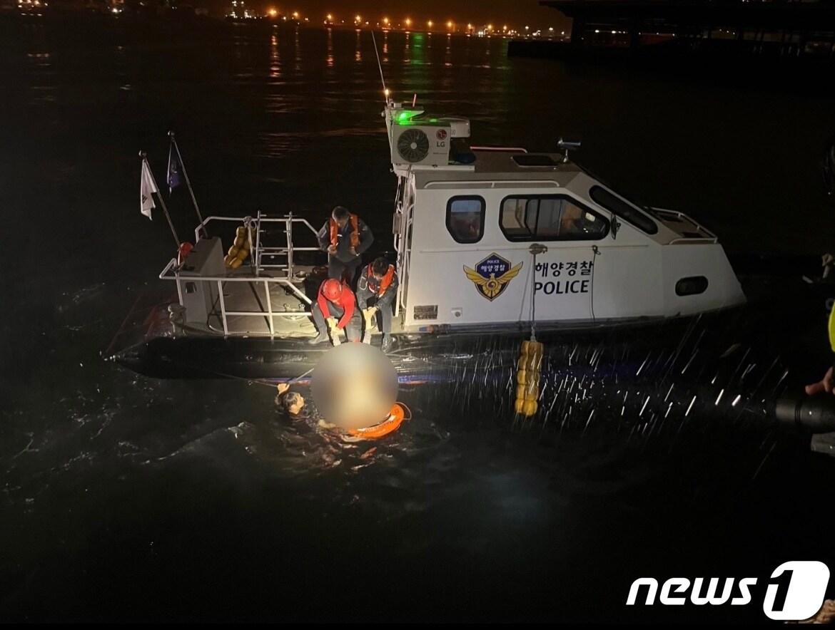 23일 오전 3시58분께 부산 감천항 인근 해상에 빠진 차량에서 자력으로 빠져나온 30대 여성을 해경이 구조하고 있다.&#40;부산해경 제공&#41;