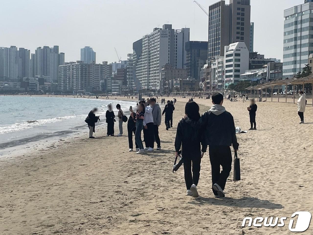 4일 오후 2시쯤 부산 수영구 광안리해수욕장 백사장에서 나들이객들이 사진을 찍고 모래 위를 걷고 있다.2023.3.4/뉴스1 강승우 기자