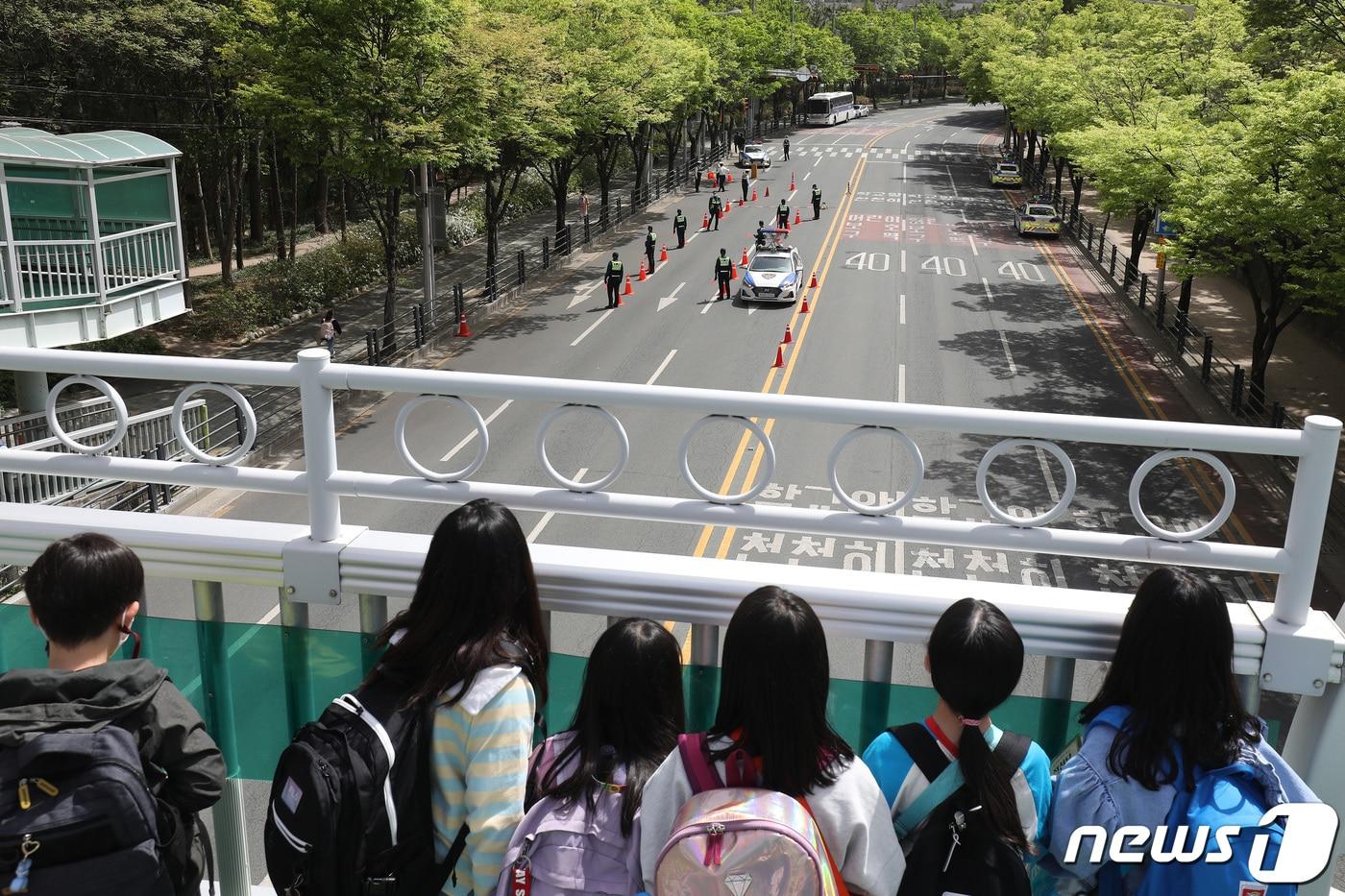 13일 오후 대구 수성구 한 초등학교 앞 어린이보호구역에서 경찰이 불시에 음주단속을 시작하자 하굣길 어린이들이 육교 위에서 단속 현장을 지켜보고 있다. 2023.4.13/뉴스1 ⓒ News1 공정식 기자