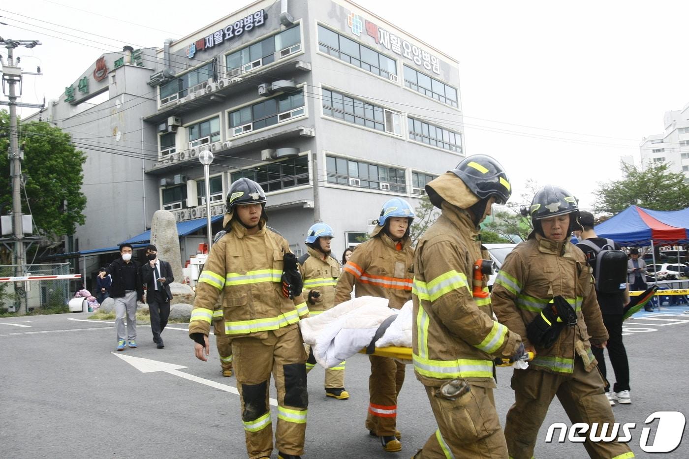 19일 전남 화순 한 요양병원에서 발생한 화재가 발생한 가운데 한 환자가 소방대원에 실려 병원으로 이송돼고 있다. 이 화재로 20명이 경상을 입고 병원으로 이송됐다. 2023.4.19 /뉴스1 ⓒ News1 김태성 기자