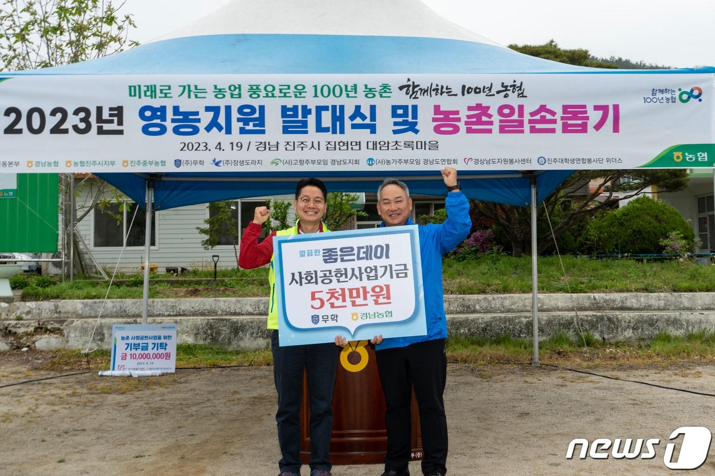 이종수 무학 사장이 지난 19일 경남 진주 집현면의 대암초록 정보화마을에서 열린 농촌 일손 돕기 봉사활동에서 김주양 경남농협 본부장에게 영농지원 사회공헌기금 5000만원을 전달하고 있다.&#40;무학 제공&#41;