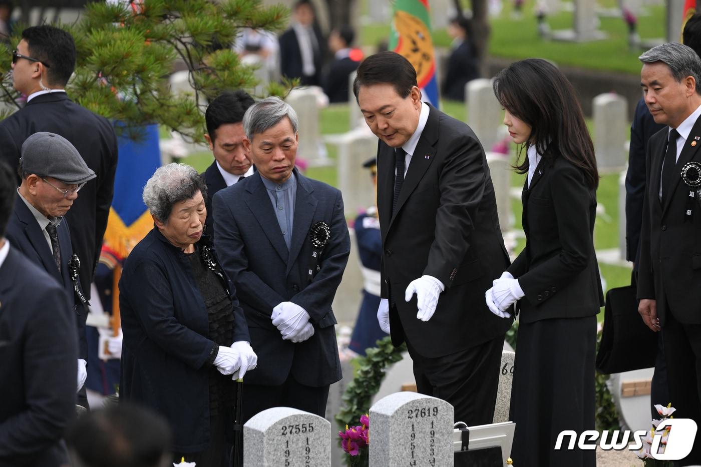 윤석열 대통령과 김건희 여사가 6일 오전 서울 동작구 국립서울현충원 52묘역에서 6‧25전쟁 전사자 故 김봉학 육군 일병의 유해를 안장하는 &#39;호국의 형제&#39; 안장식에 참석해 유가족과 고인의 묘비를 보며 대화하고 있다. 고 김봉학 일병의 유해는 동생인 고 김성학 육군 일병 묘역에 합동 안장됐다. 형제는 6‧25전쟁에 참전한 지 73년 만에 유해로 상봉했다. &#40;대통령실 제공&#41; 2023.6.6/뉴스1 ⓒ News1 안은나 기자