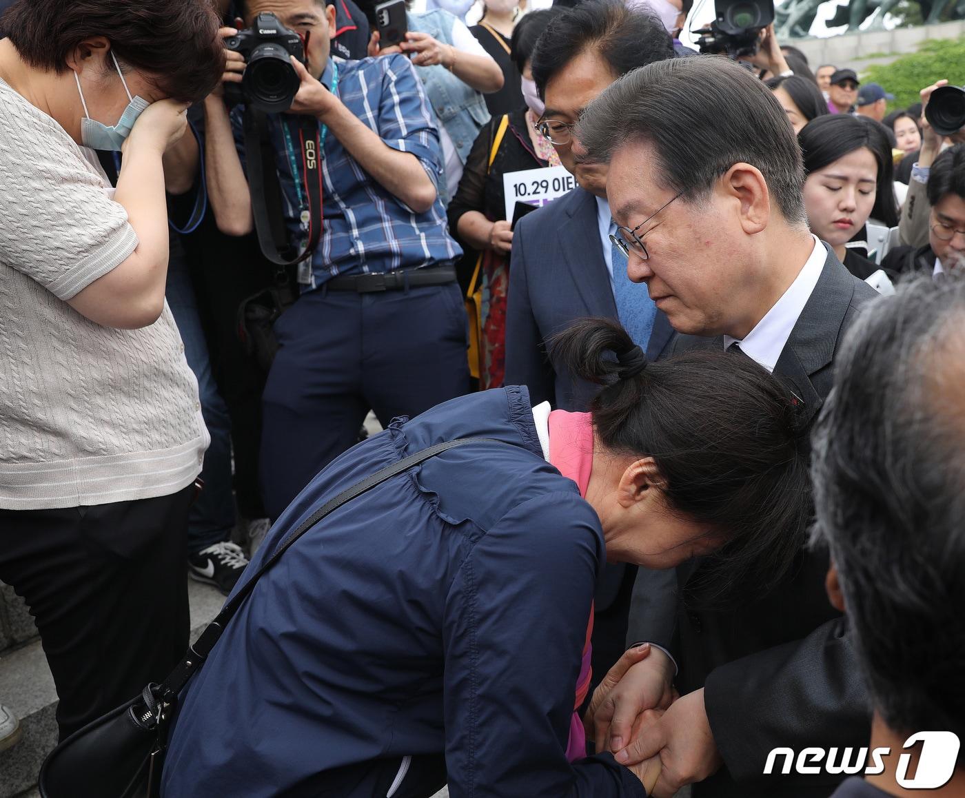 이재명 더불어민주당 대표가 7일 오전 서울 여의도 국회 본청 앞 계단에서 열린 10.29 이태원 참사 진상규명특별법 제정 촉구 국회 앞 유가족 농성 시작 기자회견에서 눈물을 흘리는 유가족의 손을 잡아주고 있다. 2023.6.7/뉴스1 ⓒ News1 임세영 기자