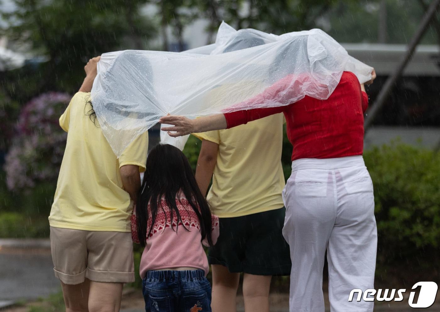 전국 곳곳에 비가 내리는 11일 오전 서울 중구 청계광장에서 우산을 준비하지 못한 외국인 관광객들이 발걸음을 재촉하고 있다. 203.7.11/뉴스1 ⓒ News1 이재명 기자