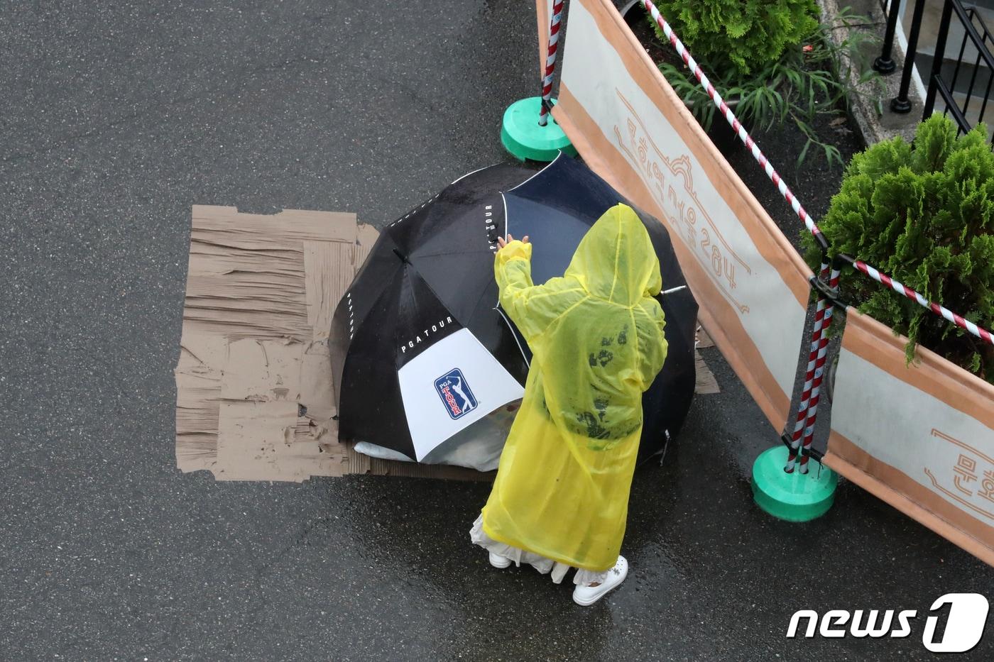 서울 중구 서울역 앞에서 한 노숙자가 자리를 보호하는 우산을 옮기고 있다. ⓒ News1 이승배 기자