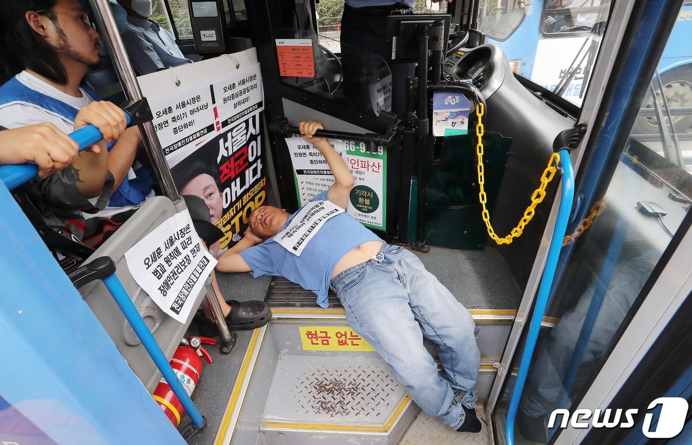 전국장애인차별철폐연대&#40;전장연&#41; 회원들이 17일 오후 서울 종로구 혜화동로터리 버스 정류장에서 전장연 탄압 중단을 촉구하며 &#39;계단 버스&#39; 탑승을 시도하고 있다. 2023.7.17/뉴스1 ⓒ News1 김진환 기자