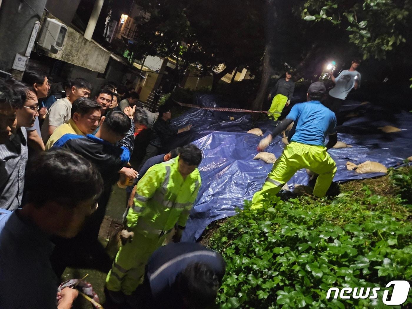 광주 남구 직원들이 17일 오후 토사 유출 가능성이 제기된 광주 남구 월산공원 인근 주택가에서 긴급 조치를 취하고 있다. 2023.7.18/뉴스1