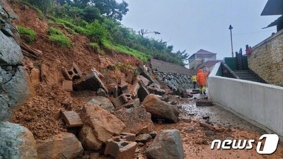 지난 16일 오후 4시 7분쯤 경남 고성군 고성읍 신월리의 도로 옆 축대가 무너져 도로에 토사가 유출돼 출동한 소방대원들이 안전조치하고 있다.&#40;경남소방본부 제공&#41;