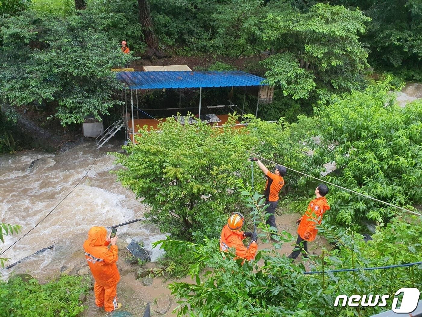 18일 오후 1시 52분쯤 밀양시 청도면 조천리에서 도랑에 물이 불어나 하천변 농막에 고립된 60·70대 여성 2명을 출동한 소방대원들이 구조하고 있다.&#40;경남소방본부&#41;