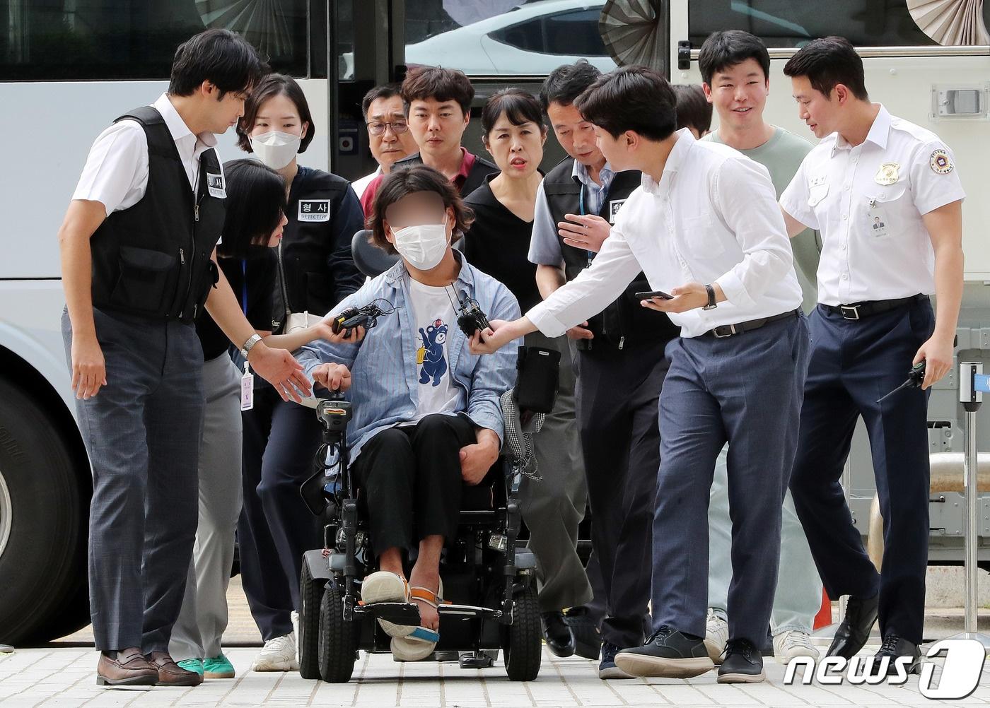 버스 시위 중 경찰 팔을 깨문 전장연 활동가 유모씨가 20일 오후 서울 서초구 서울중앙지방법원에서 열린 공무집행방해 혐의 구속영장 실질심사에 출석하고 있다. 2023.7.20/뉴스1 ⓒ News1 박세연 기자