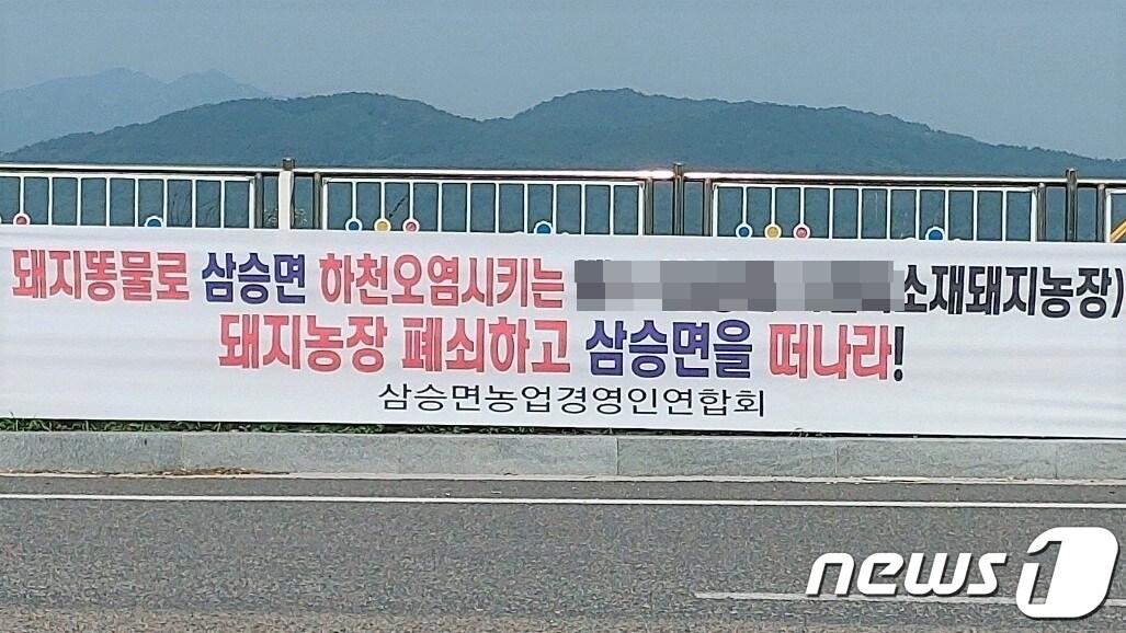 충북 보은군 삼승면사회단체협의회가 축산폐수를 무단 방류한 돼지농장을 폐쇄할 것을 촉구하고 나섰다. 사진은 삼승면 국도변에 설치한 현수막. /뉴스1 장인수 기자 