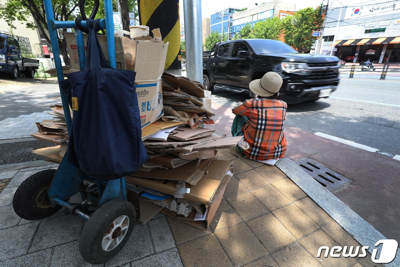 대구 서구 평리동에서 손수레에 폐지를 싣고 가던 노인이 가로수 아래 앉아 쉬고 있다.  2023.7.3/뉴스1 ⓒ News1 공정식 기자