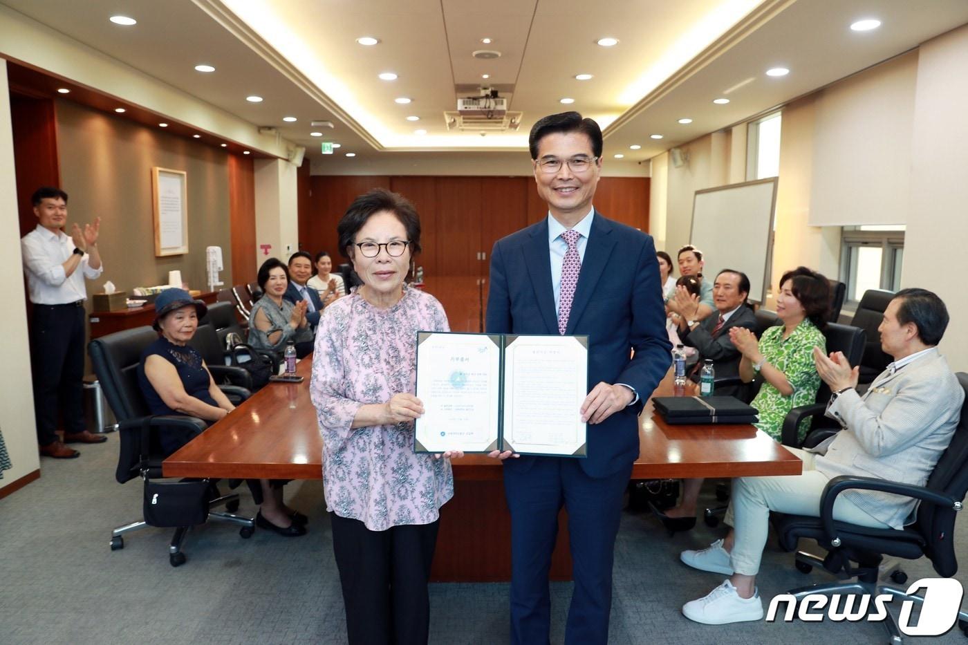 김일목 삼육대 총장&#40;오른쪽&#41;과 고 신우균 목사의 아내 문정자씨가 발전기금 약정서에 서명 후 기념사진을 찍고 있다. &#40;제공=삼육대&#41;