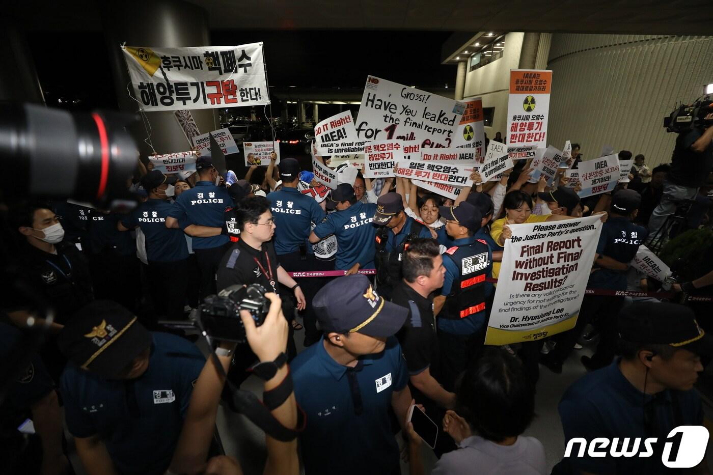 라파엘 그로시 국제원자력기구&#40;IAEA&#41; 사무총장의 입국이 예정된 7일 저녁 서울 강서구 김포공항 국제선에서 정의당과 민주노총을 비롯한 시민단체 회원들이 후쿠시마 원전 오염수 해양 방류를 규탄하며 손 피켓 시위를 하고 있다. 2023.7.7/뉴스1 ⓒ News1 이동해 기자