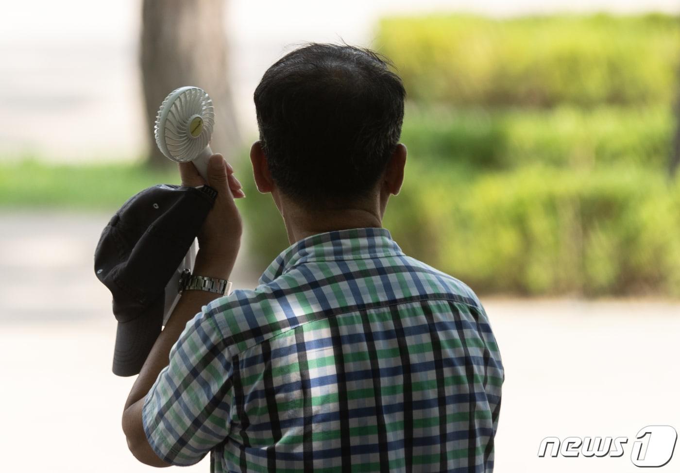 폭염으로 인한 온열질환 환자가 증가하고 있는 1일 오후 서울 종로구 탑골공원에서 한 어르신이 간이용 선풍기로 더위를 식히고 있다. 온열질환은 폭염에 장시간 노출될 때 열로 발생하는 급성질환이다. 무더위에 장시간 노출 시 두통, 어지러움, 근육경련, 피로감, 의식 저하 등의 증상을 보인다. 2023.8.1/뉴스1 ⓒ News1 이재명 기자