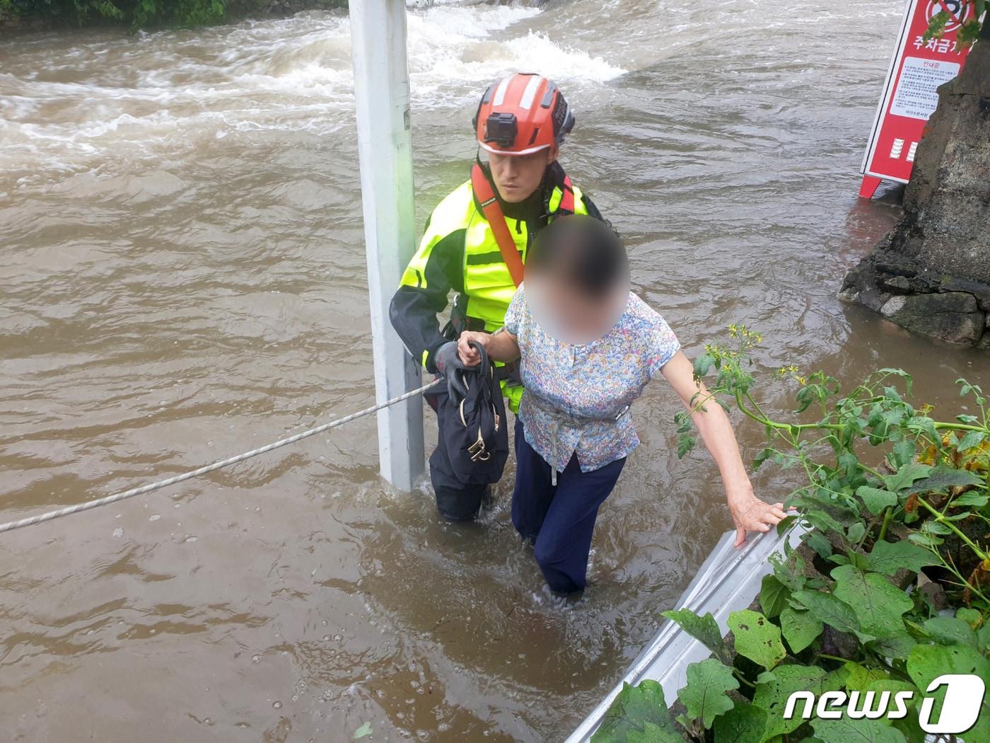 제6호 태풍 카눈이 북상한 10일 오전 경남 창원시 마산회원구에서 소방대원이 불어난 물로 고립된 주민을 구조하고 있다. &#40;소방청 제공&#41; 2023.8.10/뉴스1