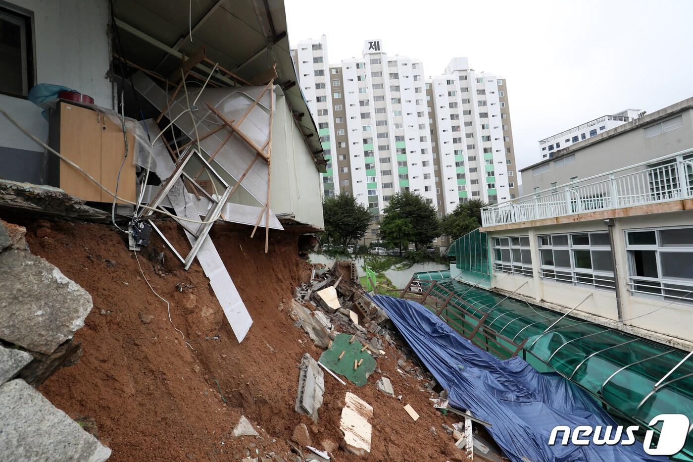 제6호 태풍 &#39;카눈&#39;이 지나간 10일 오후 부산 금정구 금정중학교 인근 공장의 옹벽이 태풍의 영향으로 무너지며 유출된 토사가 학교로 쏟아져 교실 등이 파손돼 있다. 이 학교는 지난달 개학했으나, 태풍 북상에 따라 이날 원격 수업을 진행해 학생 등의 인명 피해는 없었다. 2023.8.10/뉴스1 ⓒ News1 윤일지 기자