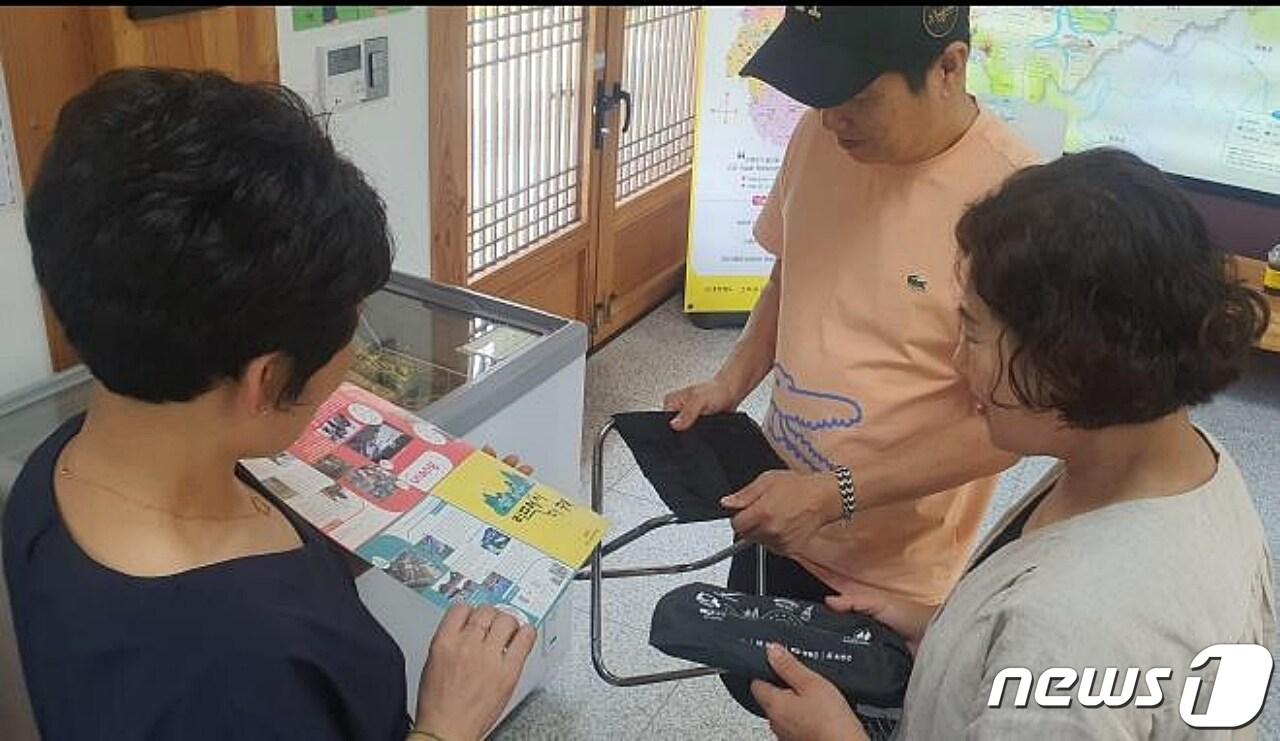 충북 보은군과 옥천군, 영동군이 관광 활성화를 위해 의기투합해 관광 홍보에 열을 올리고 있다. 사진은 스탬프 투어 관광객에게 기념품을 지급하는 모습.&#40;옥천군 제공&#41;/ 뉴스1