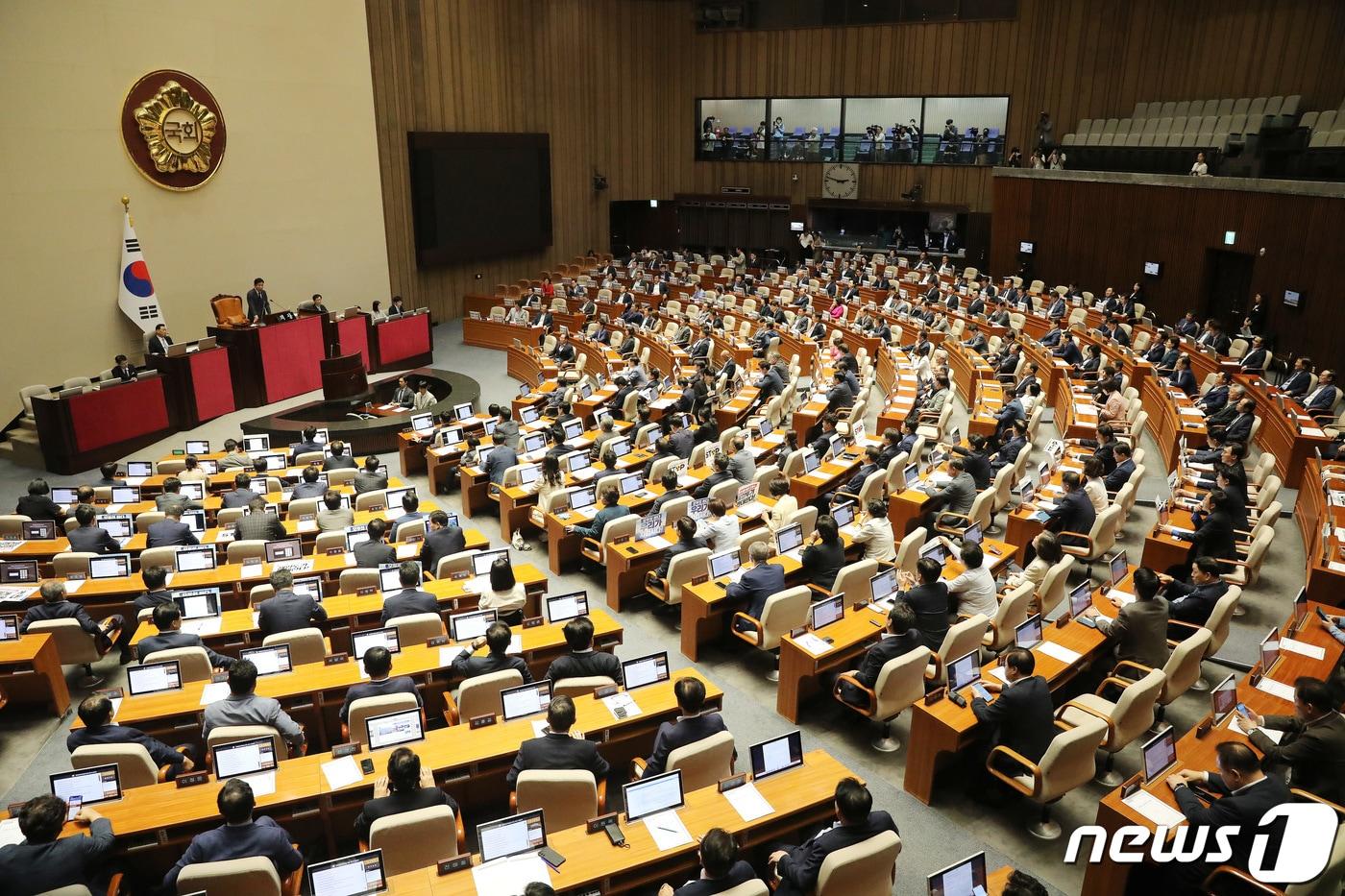 24일 오후 서울 여의도 국회에서 열린 제409회 국회&#40;임시회&#41; 제1차 본회의에서 국민의힘 의원들은 &#39;방탄국회 회기꼼수, 민주당은 각성하라&#39;가 적힌 피켓을, 더불어민주당 의원들은 &#39;후쿠시마 원전오염수 해양투기 반대한다&#39;가 적힌 피켓을 붙이고 있다. 2023.8.24/뉴스1 ⓒ News1 임세영 기자