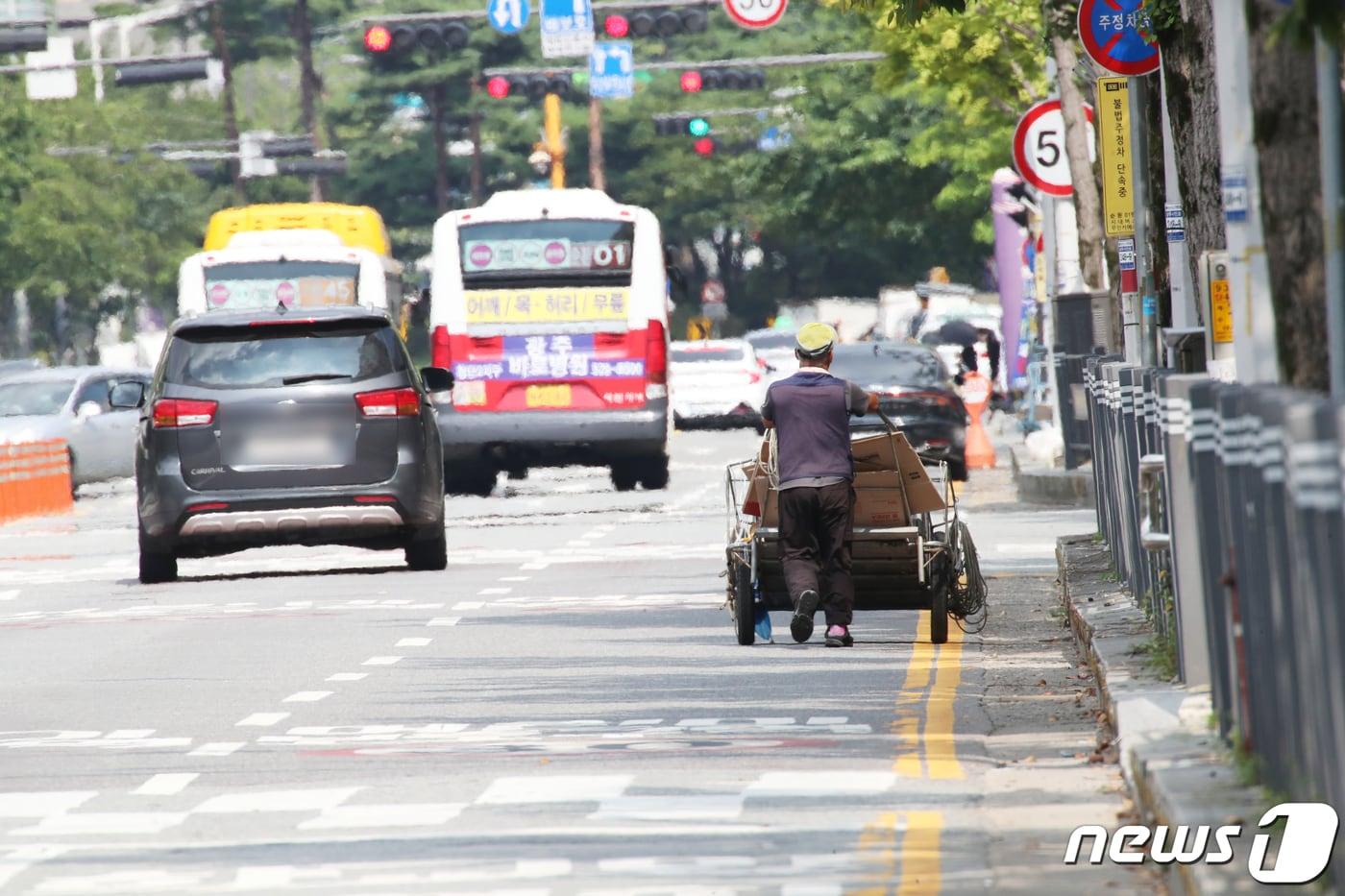 폭염이 이어지고 있는 3일 광주 서구 한 도로에서 폐지줍는 한 어르신이 손수레를 끌고 도로를 지나고 있다.2023.8.3/뉴스1 ⓒ News1 김태성 기자