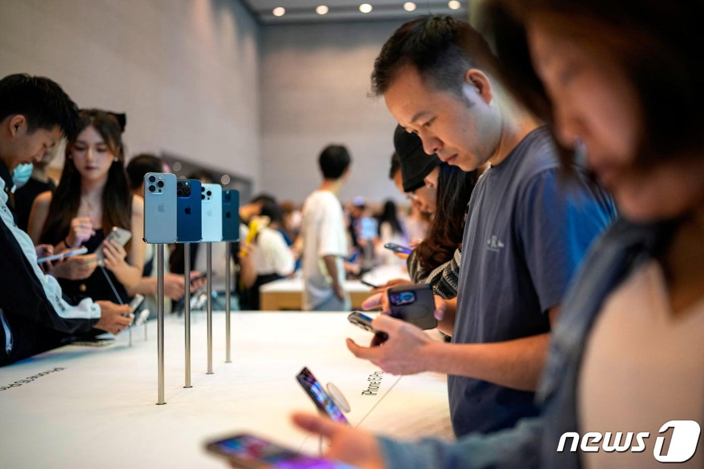 22일&#40;현지시간&#41; 아이폰15 시리즈 신제품 출시 첫날 중국 상하이의 애플 매장에서 고객들이 제품을 살펴 보고 있다. 가운데에는 아이폰15 프로 모델이 전시돼있다. 2023.09.22 ⓒ 로이터=뉴스1 ⓒ News1 우동명 기자