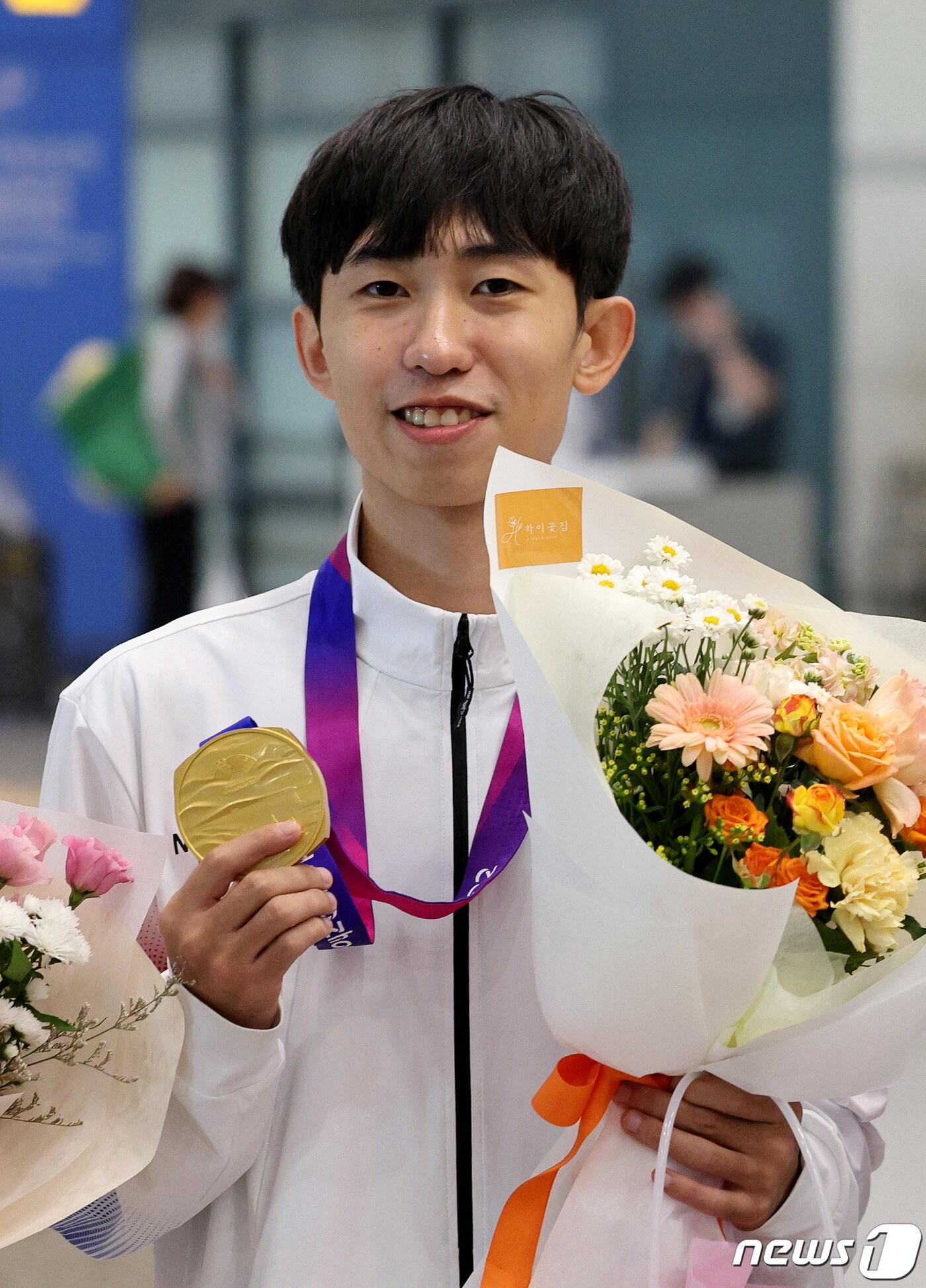 항저우 아시안게임 태권도 품새 금메달리스트 강완진이 25일 오후 인천국제공항 제1터미널을 통해 귀국한 뒤 금메달을 들어보이고 있다. 2023.9.25/뉴스1 ⓒ News1 장수영 기자