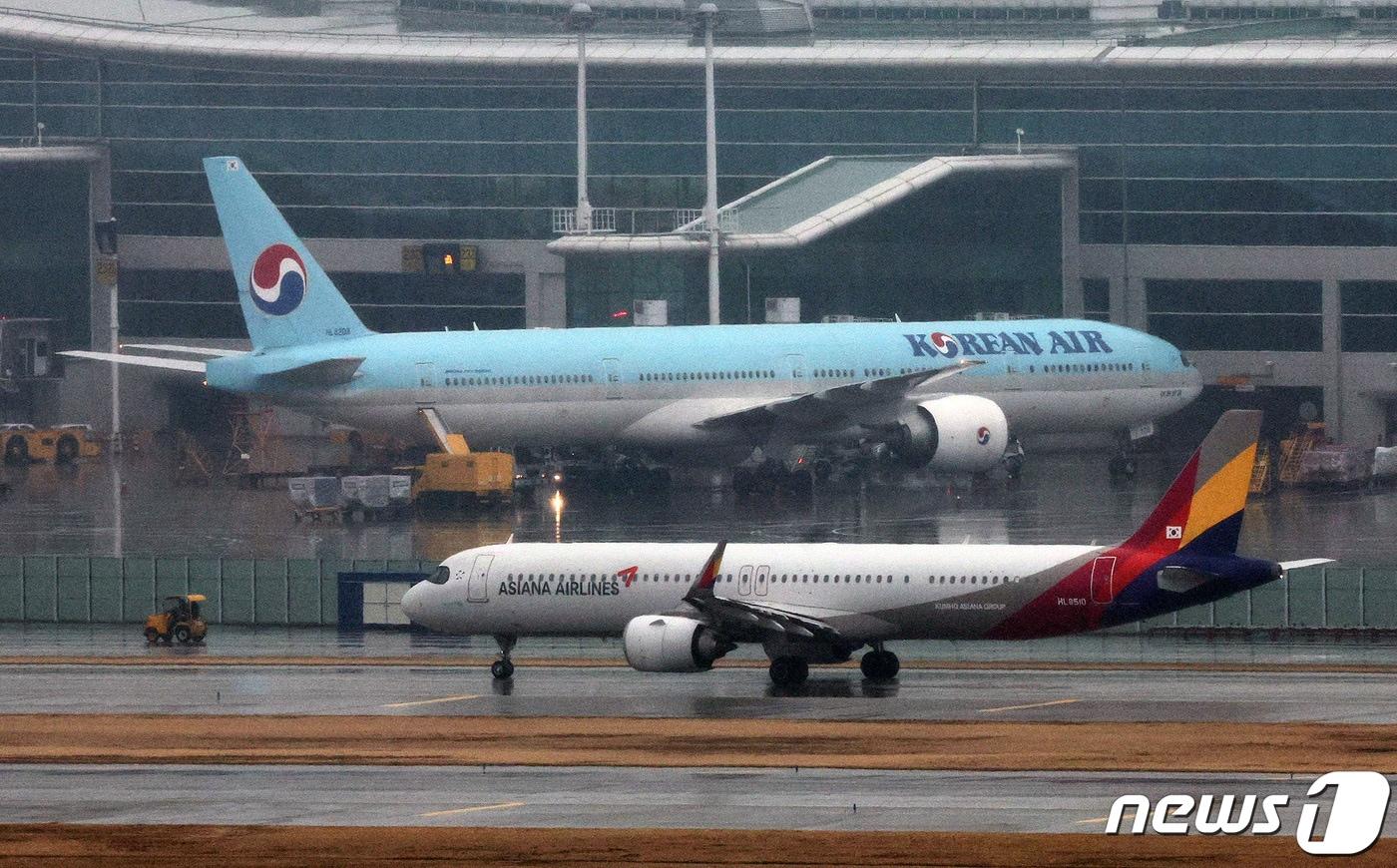 인천국제공항 계류장에 세워진 대한항공 항공기 앞으로 아시아나 항공기가 지나가고 있다. 2024.1.14/뉴스1 ⓒ News1 장수영 기자