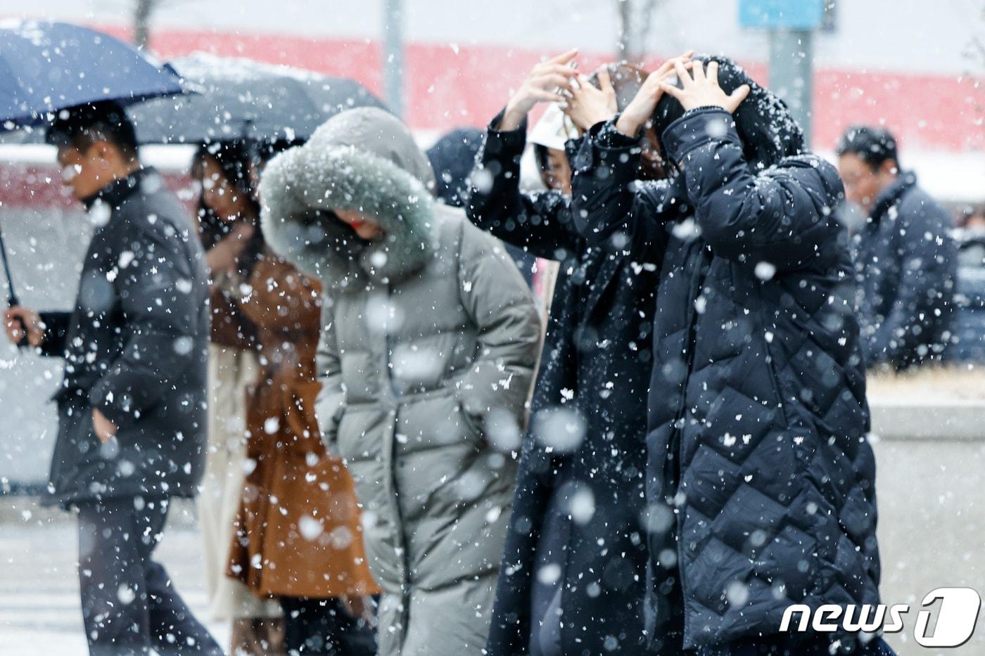 서울 지역에 눈이 내리는 17일 여의도에서 직장인들이 점심식사를 하기 위해 이동하고 있다. 2024.1.17/뉴스1 ⓒ News1 안은나 기자