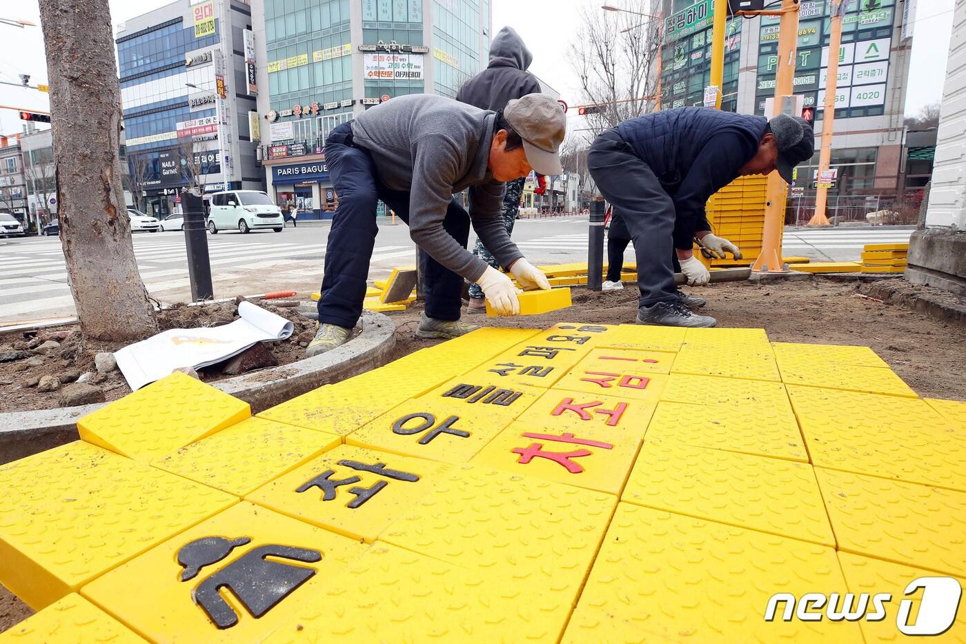  광주 북구 일곡동의 한 초등학교 앞 횡단보도에서 북구청 교통과 교통시설팀 직원들이 아이들의 안전한 통학로 환경 조성을 위해 옐로카펫을 설치하고 있다. &#40;광주 북구청 제공&#41;/뉴스1 ⓒ News1 김태성 기자