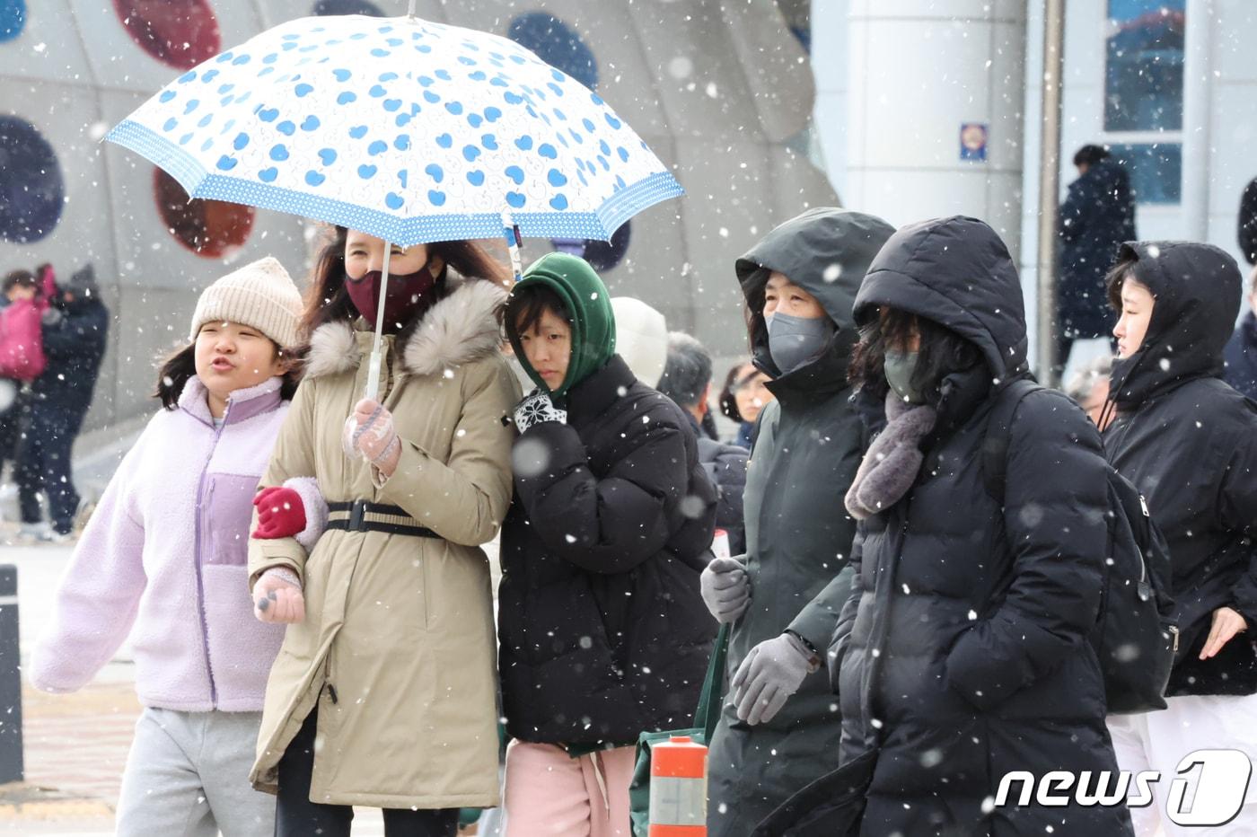 광주와 전남 7개 시군&#40;나주·목포·영암·무안·함평·장성·영광&#41;에 대설주의보가 내려진 22일 오후 광주시 광산구 송정역앞에서 시민들이 눈을 맞으며 걷고 있다.2024.1.22/뉴스1 ⓒ News1 김태성 기자