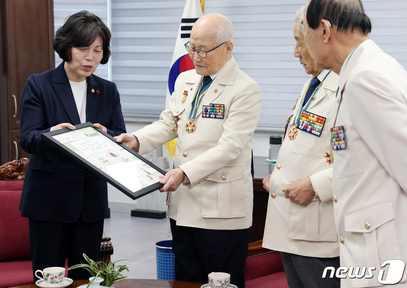 강정애 국가보훈부 장관이 25일 서울 강동구 호국영웅보훈회관에서 손희원 대한민국6·25참전유공자회장에게 &#39;영웅의 제복&#39; 액자와 부산 동신초등학교 학생들의 감사 손편지가 담긴 액자를 헌정하고 있다. 2024.1.25/뉴스1 ⓒ News1 이동해 기자