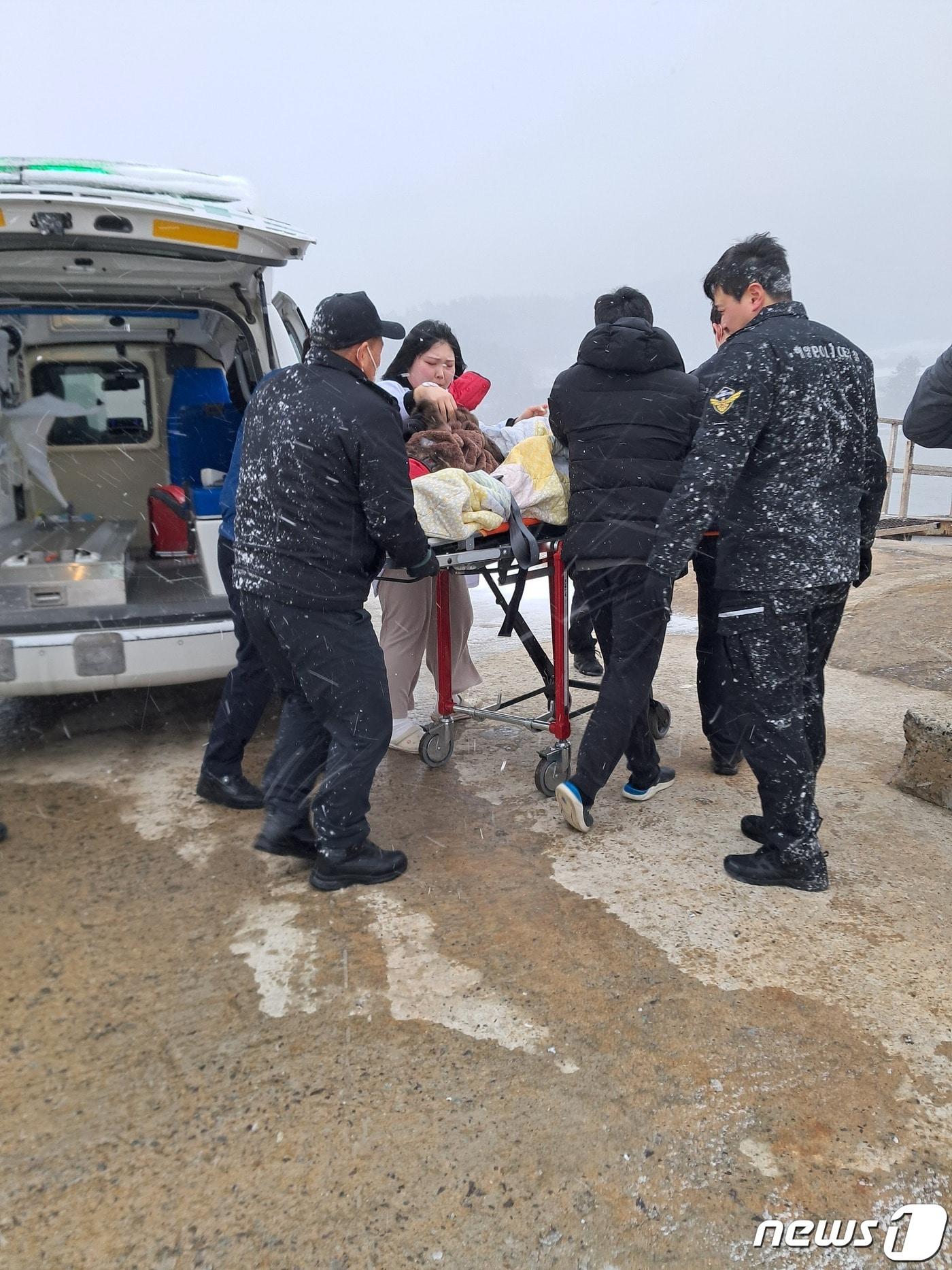 조도보건지소 직원들과 119대원들이 저체온증으로 쓰러진 응급환자를 해경 함정에 태워 진도로 이송하기 위해  서두르고 있다.&#40;진도군 제공&#41;/뉴스1