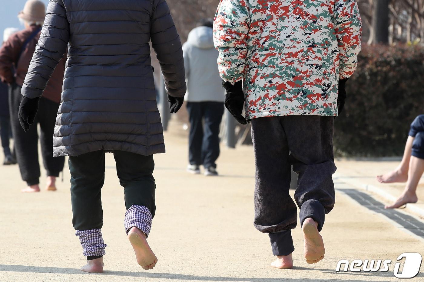 대구 수성못을 찾은 시민들이 산책로를 따라 맨발로 걷고 있다. 2024.1.30/뉴스1 ⓒ News1 공정식 기자