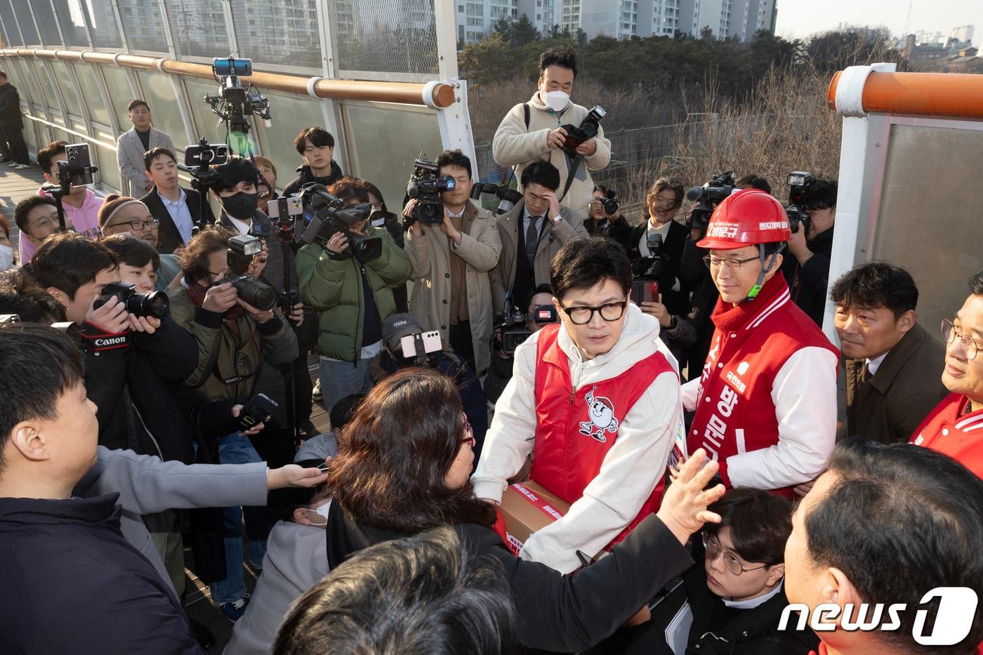 경기지역에서의 승리를 위해 국민의힘이 수원지역 공략에 총력을 기울이고 있다. 사진은 철도 지하화 공약을 발표한 한동훈 국민의힘 비상대책위원장이 지난 1월31일 수원시 천천동보도육교에서 지역 주민과 동행하며 애로 사항을 청취하고 있다. &#40;공동취재&#41; 2024.1.31/뉴스1 ⓒ News1 송원영 기자