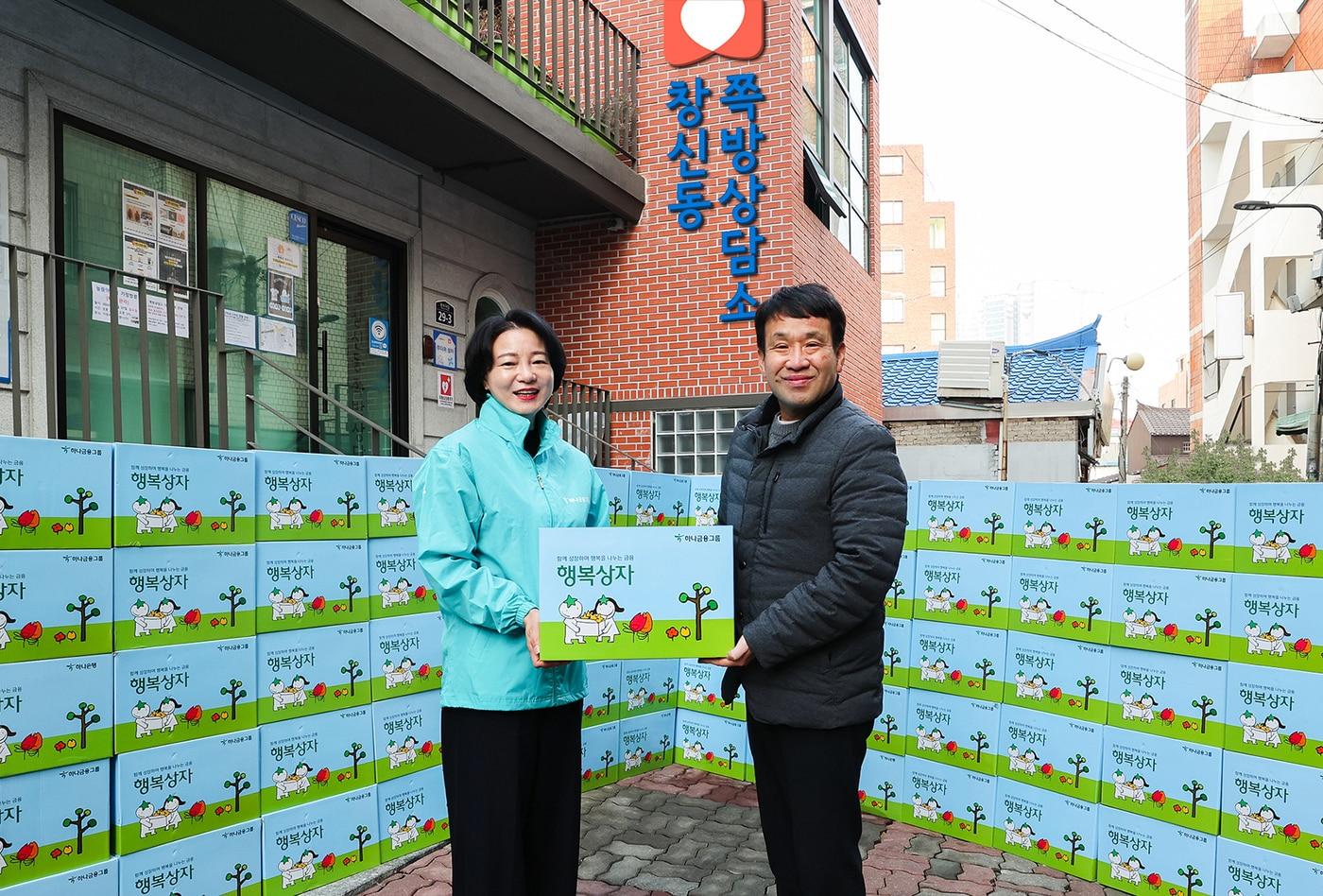 김덕순 하나은행 북부영업본부 지역대표&#40;사진 오른쪽&#41;가 창신동 인근 쪽방촌에 찾아가 독거 어르신에게 행복상자를 전달하고 있다.&#40;하나금융그룹 제공&#41;