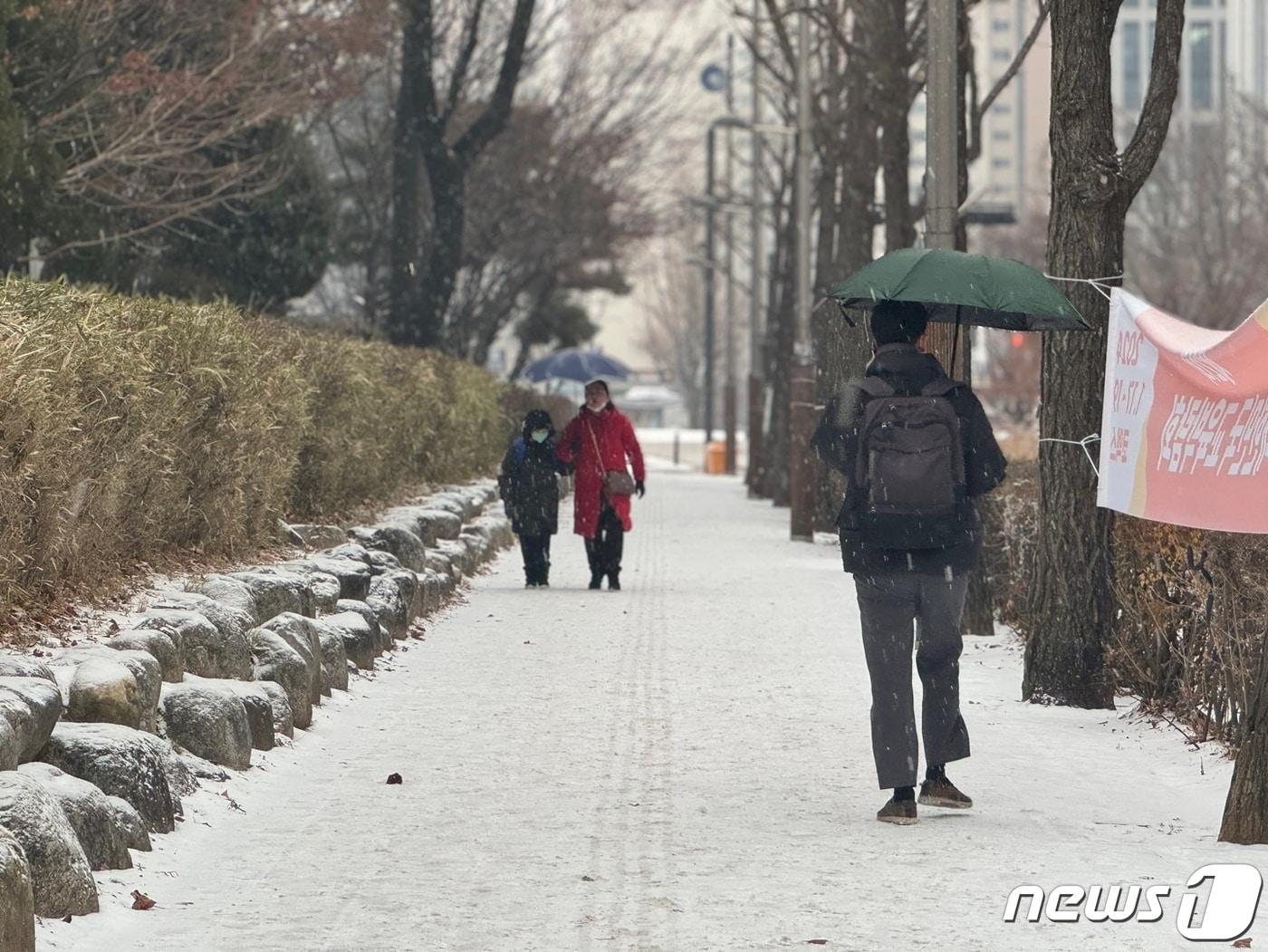 눈이 내리는 9일 오전 인천 남동구 인천시청 앞에서 시민들이 우산을 쓰고 발걸음을 옮기고 있다. 이날 오전 옹진군을 제외한 인천에는 대설주의보가 내려졌다. 2024.1.9/뉴스1 ⓒ News1 박소영 기자