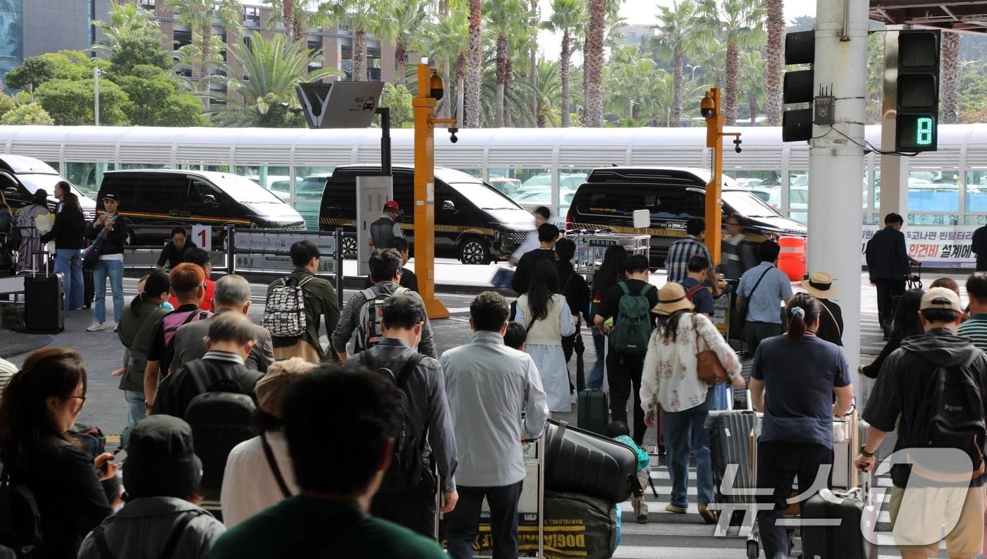 본격적인 징검다리 연휴가 시작된 1일 오전 제주국제공항에 도착한 관광객들이 길을 건너고 있다. 제주관광협회는 지난 27일부터 10월6일까지 제주에 39만명이 찾을 것이라고 전망했다.2024.10.1/뉴스1 ⓒ News1 고동명 기자