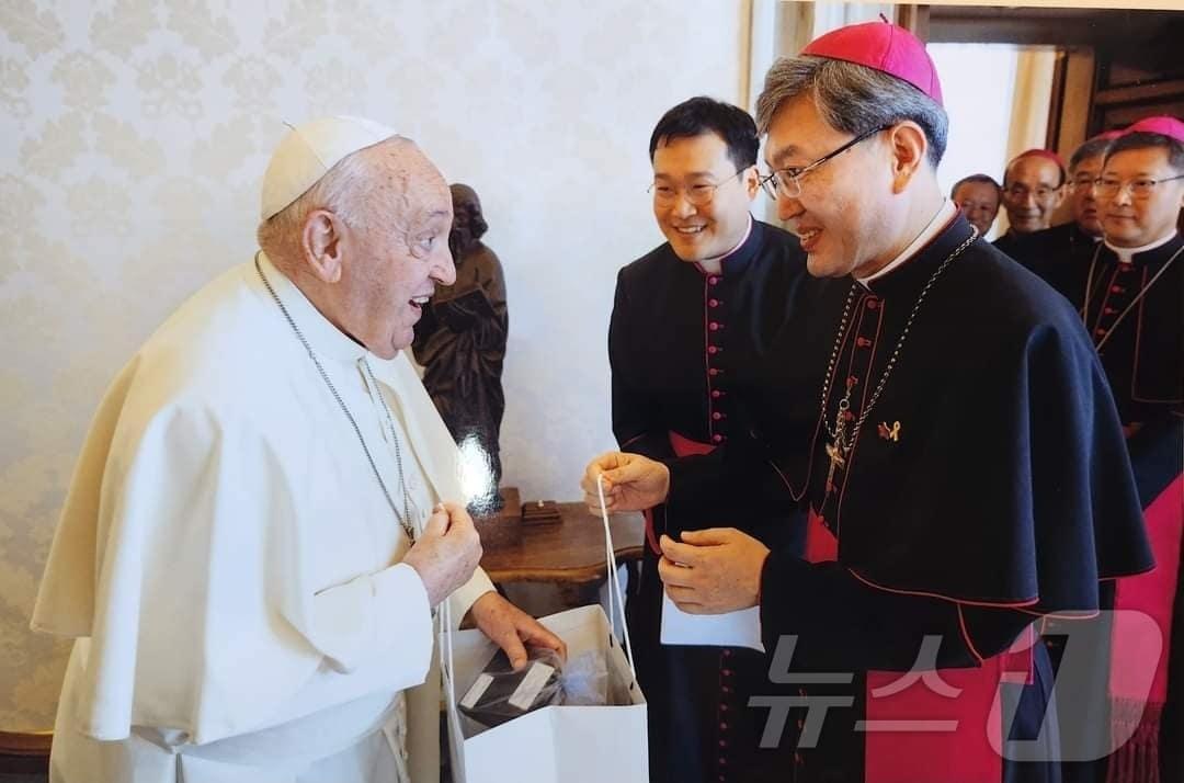 옥현진 천주교 광주대주교가 프란치스코 교황에게  &#39;K-십자가&#39;를 성물로 전달하고 있다.&#40;심상무 작가 제공&#41;/뉴스1