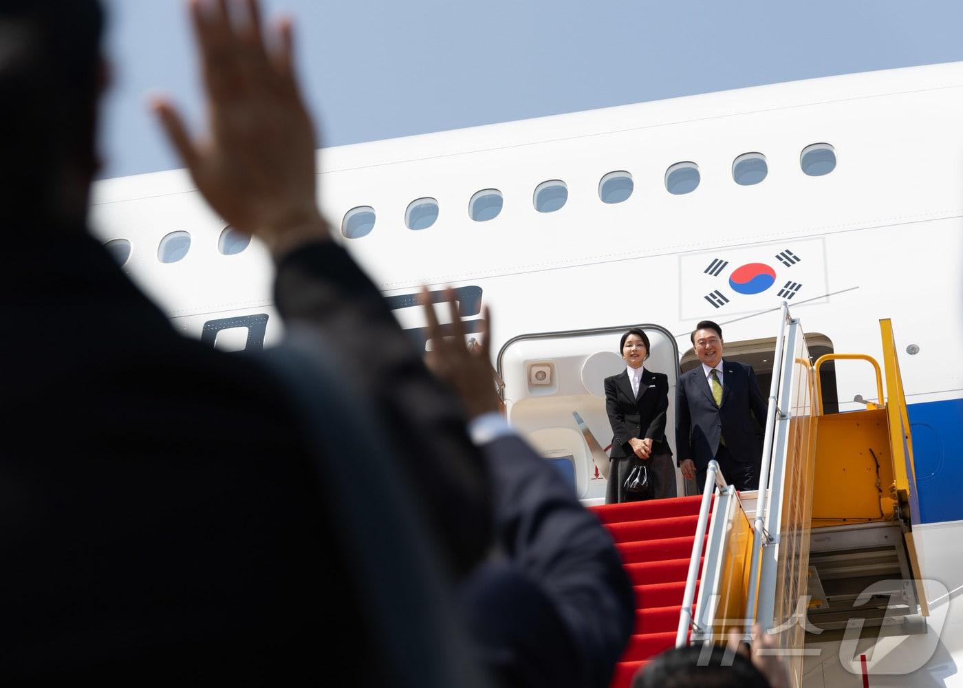 윤석열 대통령과 부인 김건희 여사가 11일&#40;현지시간&#41; 라오스 비엔티안 왓타이 국제공항에서 귀국하기 전 전용기에 올라 환송객들과 인사하고 있다. &#40;대통령실 제공&#41;/뉴스1 ⓒ News1 송원영 기자