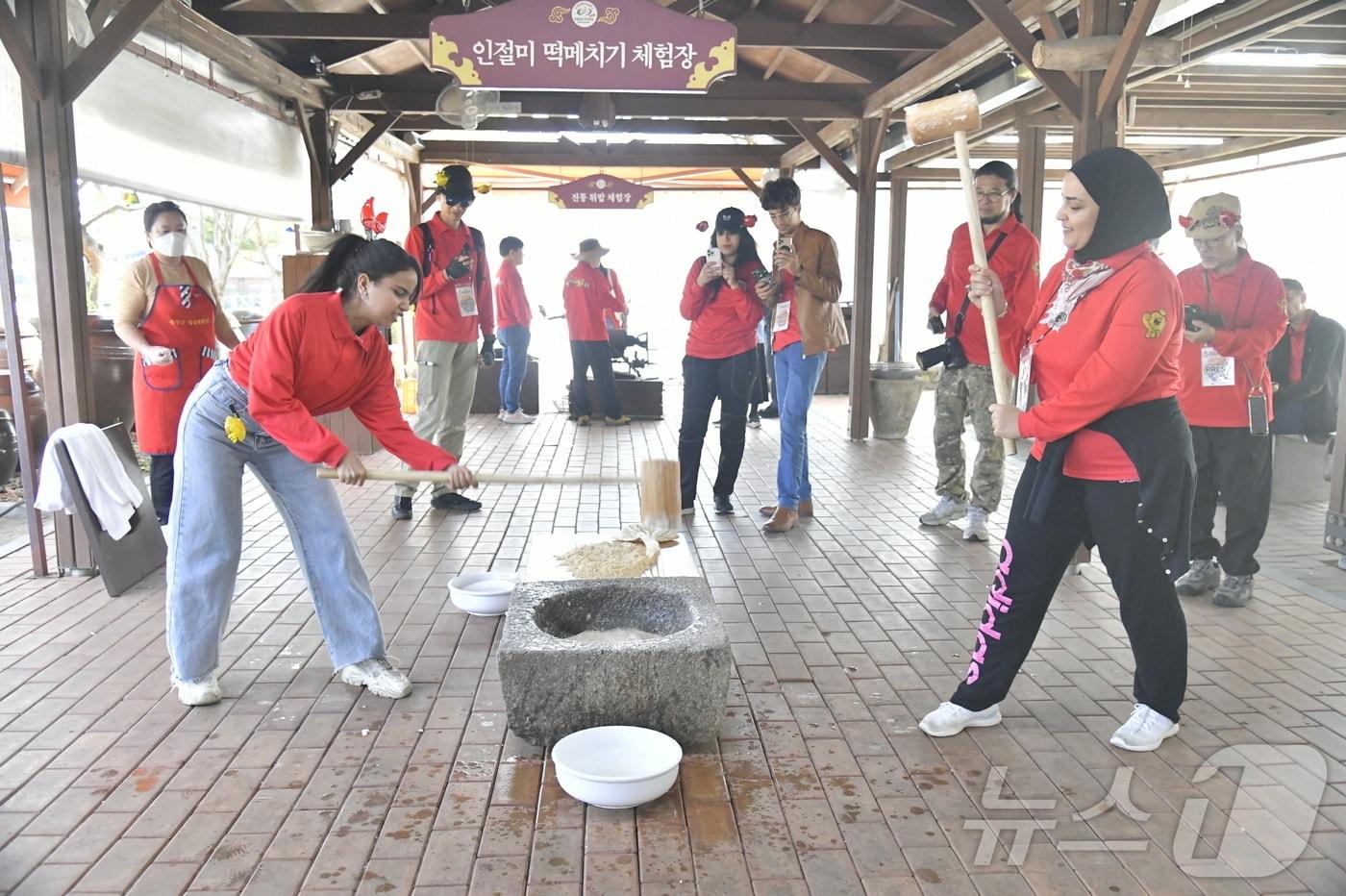 제19회 순창장류축제가 한창인 12일 순창장류체험관에서 외국인들이 인절미 만들기 체험 중 하나인 떡매치기를 하고 있다.&#40;순창군 제공&#41;/뉴스1 