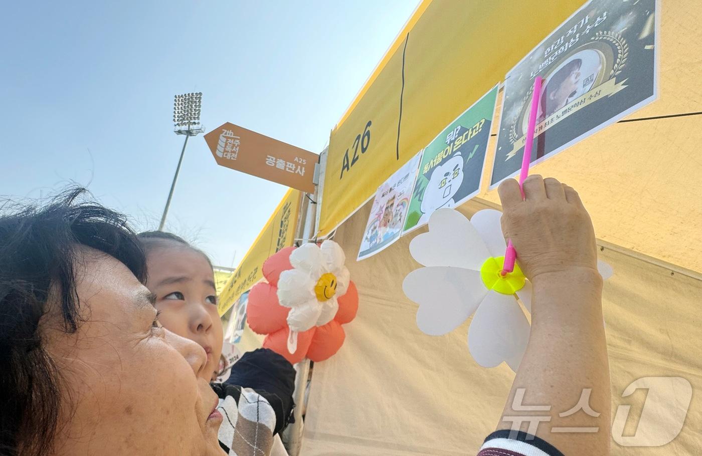 12일 오전 10시께 찾은 전북 전주종합경기장에서 최 모 씨&#40;67·전주&#41;가 손녀딸을 안고 &#39;한강 작가&#39;를 알려주는 모습. 2024.10.12/뉴스1 장수인 기자