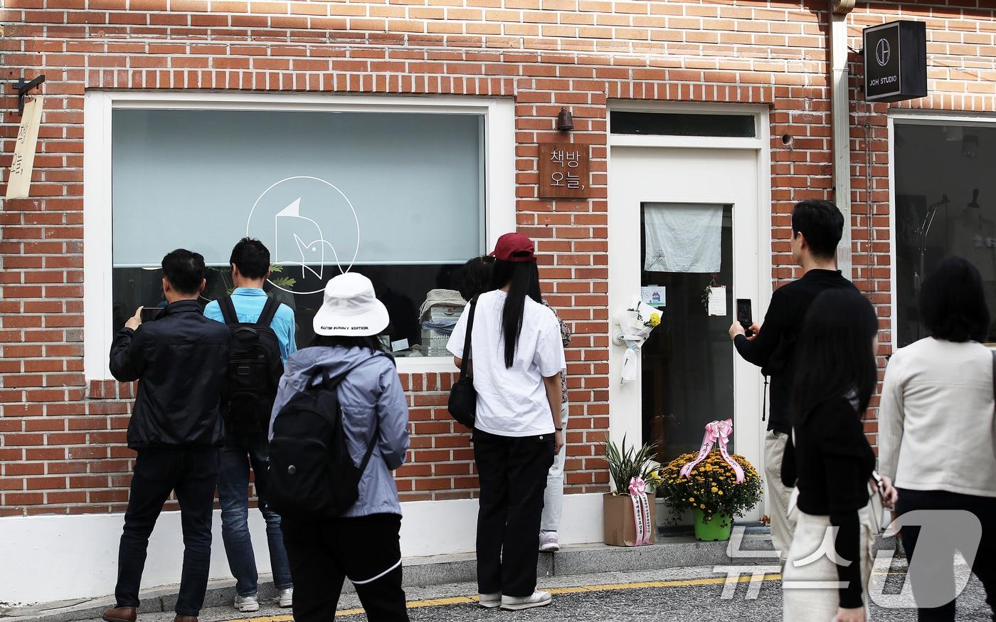 지난 13일 노벨문학상을 수상한 작가 한강이 대표로 있는 서울 종로구 독립서점 &#39;책방오늘&#39;을 찾은 시민들이 문 닫힌 서점 앞에서 인증샷을 찍고 있다.  /뉴스1 ⓒ News1 오대일 기자