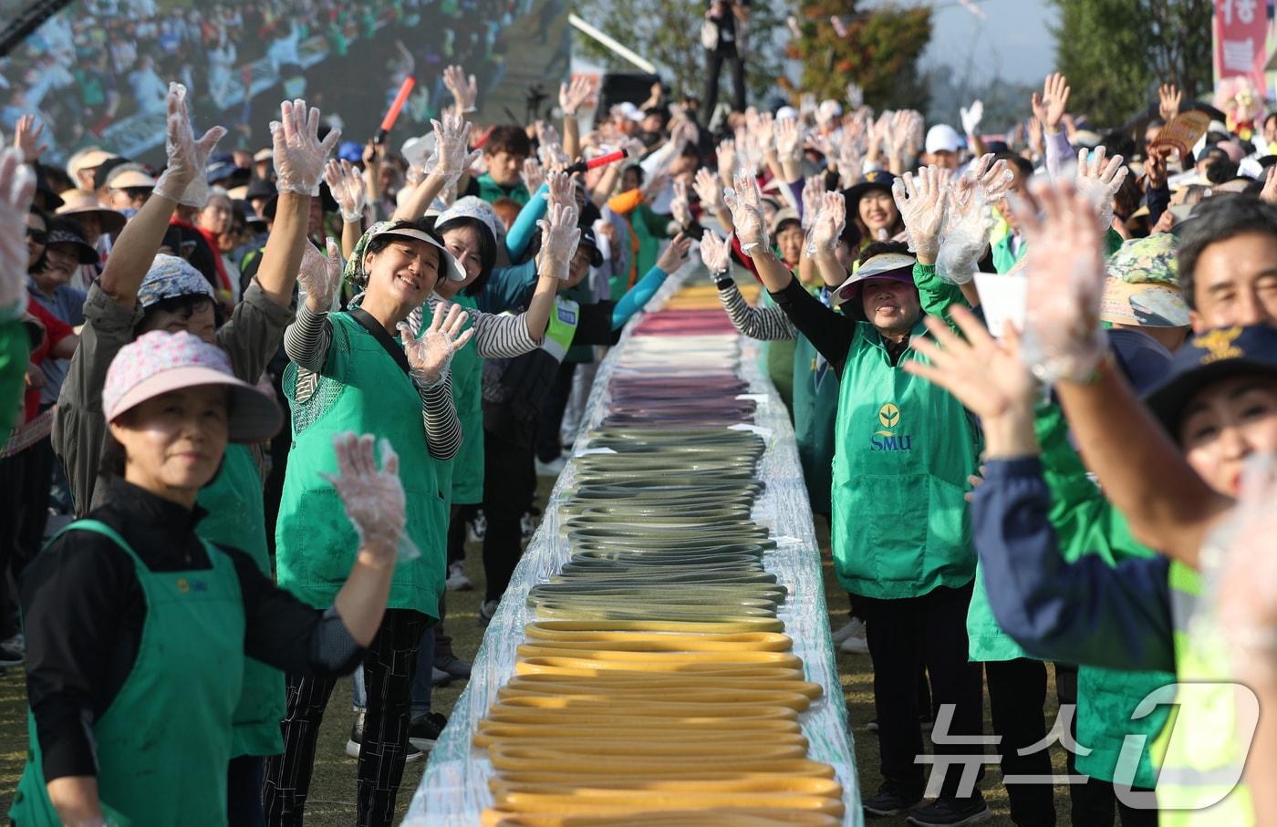 ‘제23회 이천쌀문화축제’가 개막한 16일 오후 경기 이천시 모가면 이천농업테마공원에서 행사 관계자들이 600m 가래떡을 만들고 기념촬영을 하고 있다. 2024.10.16/뉴스1 ⓒ News1 김영운 기자