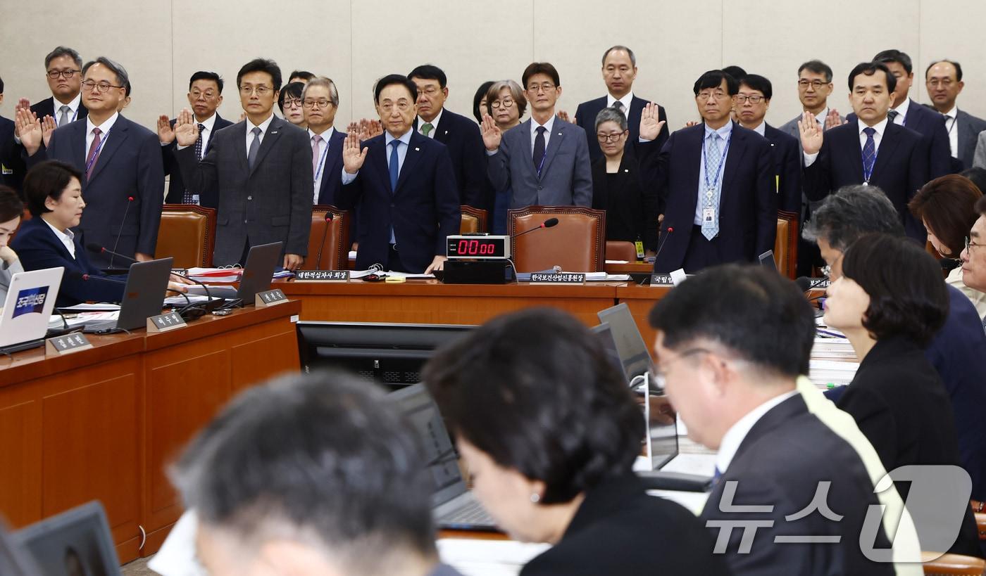 주영수 국립중앙의료원장 등 증인 및 참고인들이 17일 오전 서울 여의도 국회 보건복지위원회에서 열린 한국보건산업진흥원, 한국건강증진개발원, 국립암센터 등에 대한 국정감사에서 증인 선서를 하고 있다. 왼쪽부터 주 원장, 김헌주 한국건강증진개발원장, 김철수 대한적십자사 회장, 서홍관 국립암센터원장, 이재태 한국보건의료연구원장. 2024.10.17/뉴스1 ⓒ News1 김민지 기자